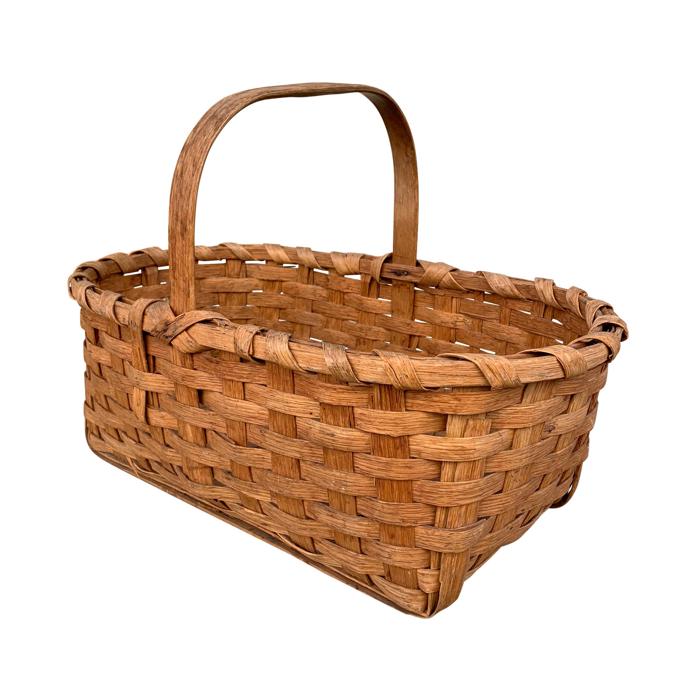 A fantastic early 20th century American oak splint basket with one bentwood handle, banded rim, and two long splints running the length of the basket.