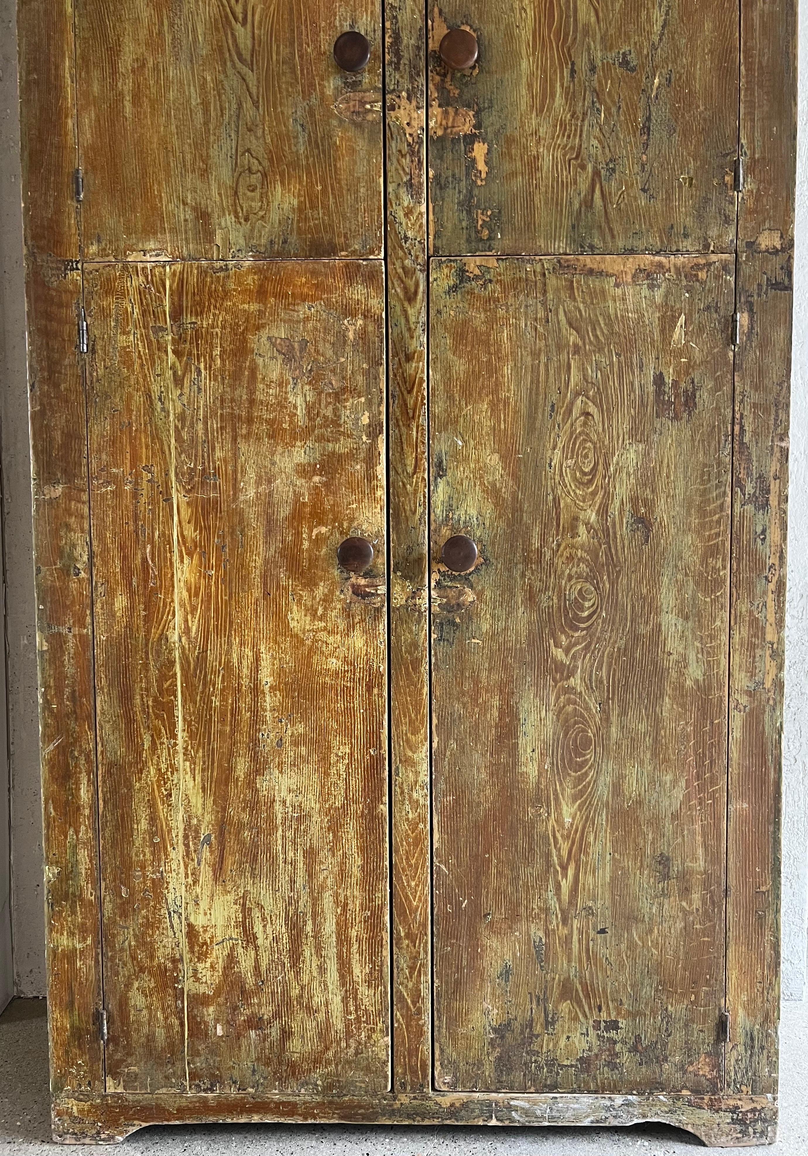 Gorgeous patina is the highlight of this Early 20th Century American Cupboard / Cabinet. The layers of paint have been worn over time allowing the most interesting of colorations. Sturdy, well maintained for its age, the piece would be wonderful in