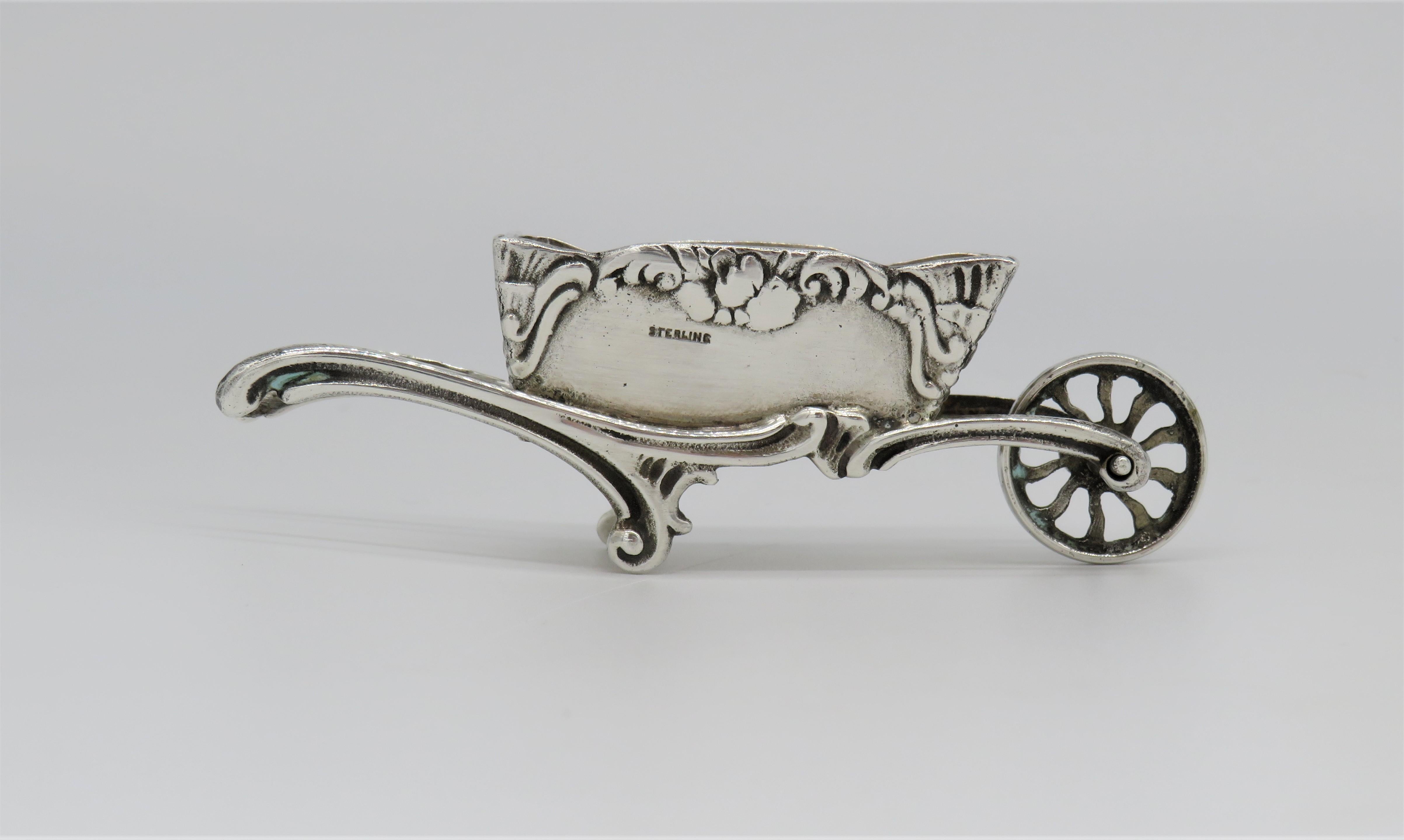 Sterling silver Charoset dish in the shape of a wheelbarrows. The wheel does rotate allowing the wheelbarrow to be rolled across the table.
Both sides of the dishes are decorated with floral design and one side is bearing the Hebrew word:
