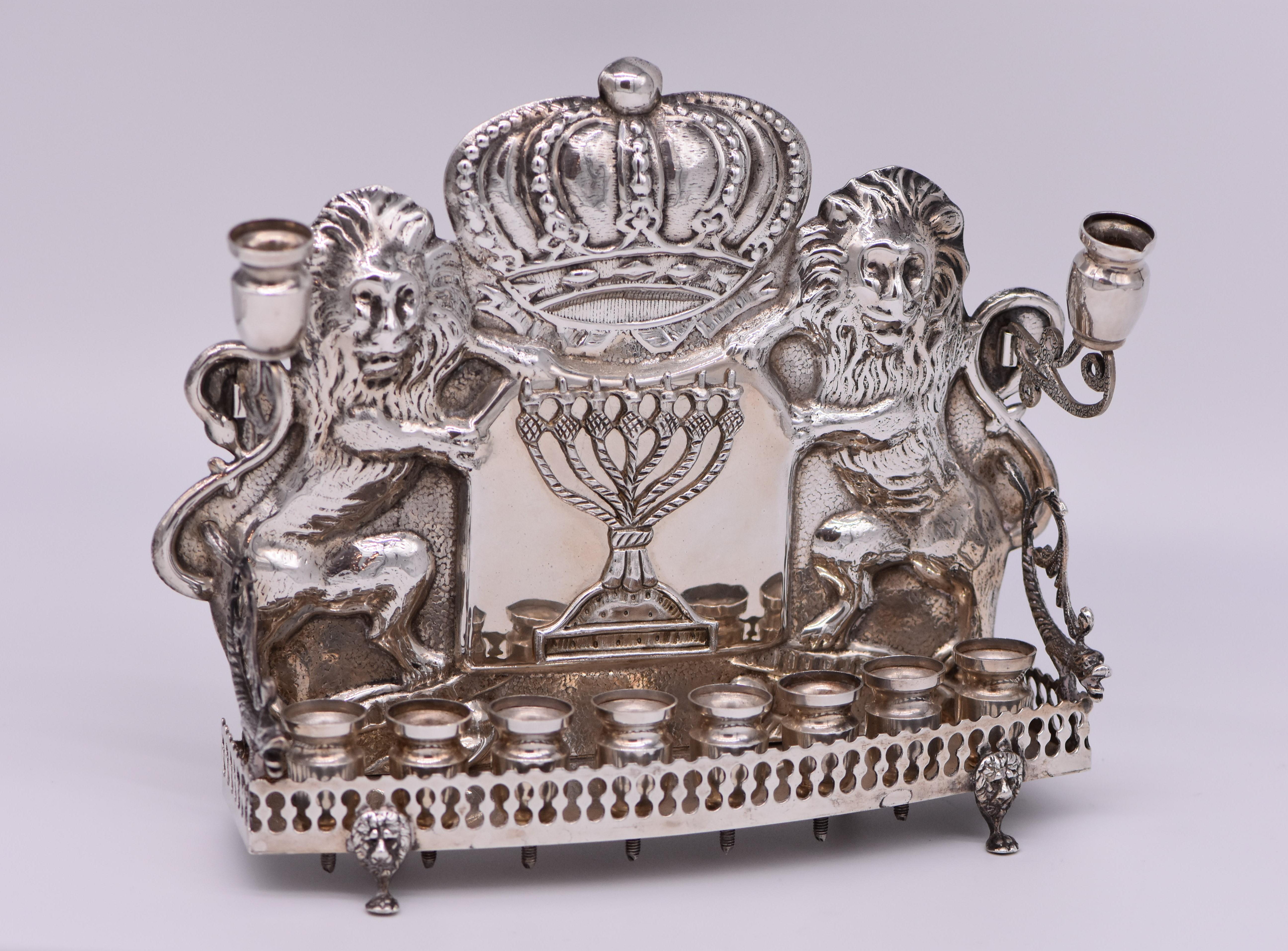 American sterling silver Hanukkah lamp, Lower east side, New York, circa 1900
The backplate embossed with a crown flanked with two lions, and applied with the Temple Menorah in the center. The front fitted with eight candle holders behind decorative