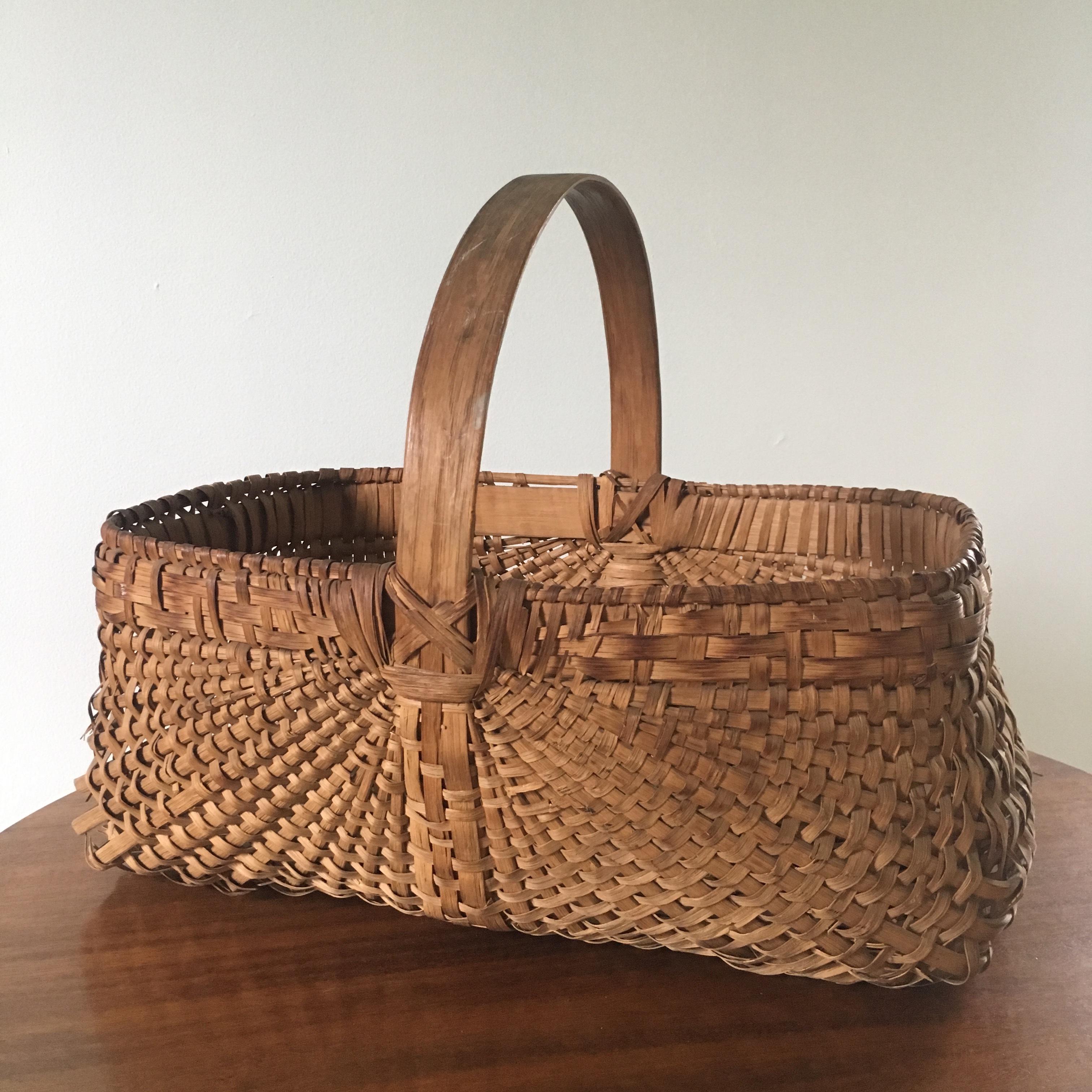 A late 19th/early 20th century American splint oak gathering basket with bentwood handle.
 