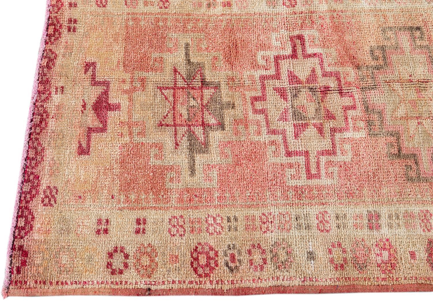 Beautiful Anatolian Village Turkish Runner rug, hand knotted wool with a coral field, ivory, tan and pink accents in geometric multi medallion design.

 This rug measures 2' 10