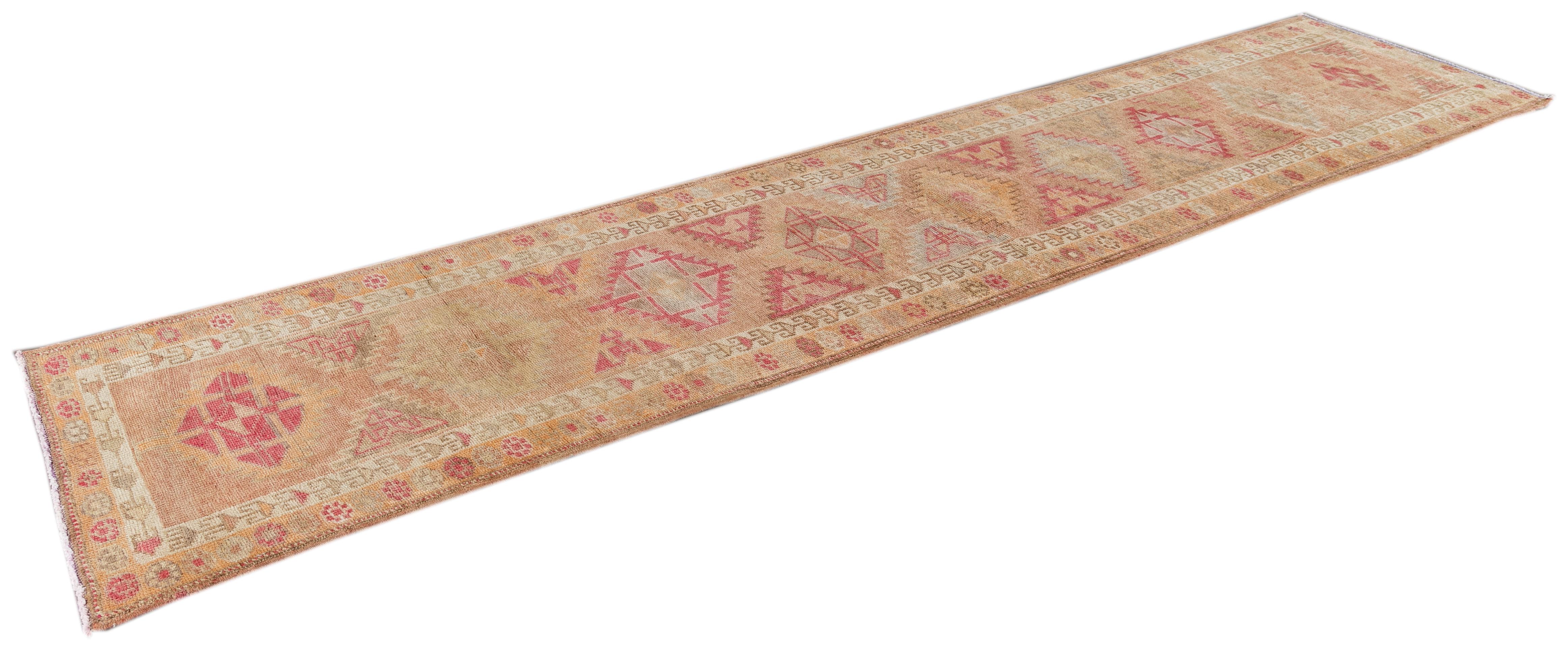 Beautiful Anatolian Turkish Runner rug, hand knotted with a coral field, ivory, tan and pink accents in all-over geometric medallion design.

 This rug measures 2' 9