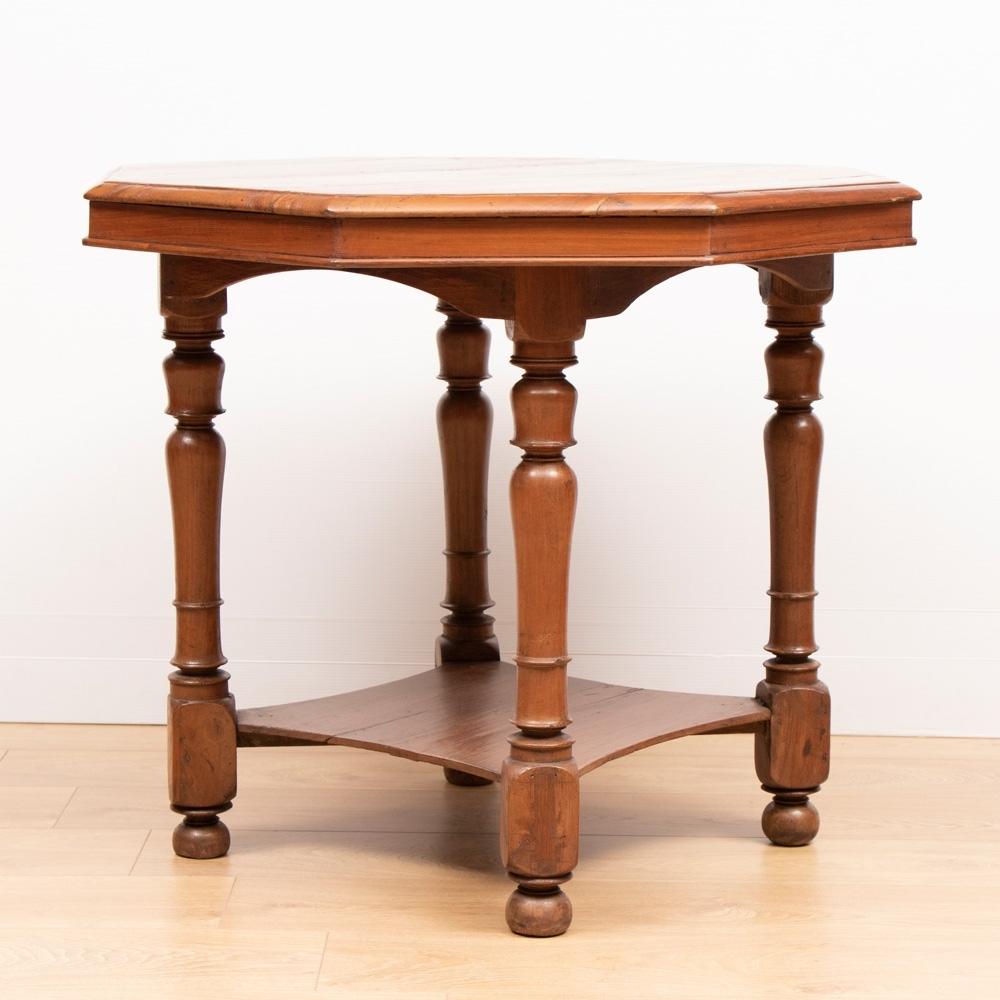 A colonial style side table with octagonal top, turned legs, bun feet and lower shelf.