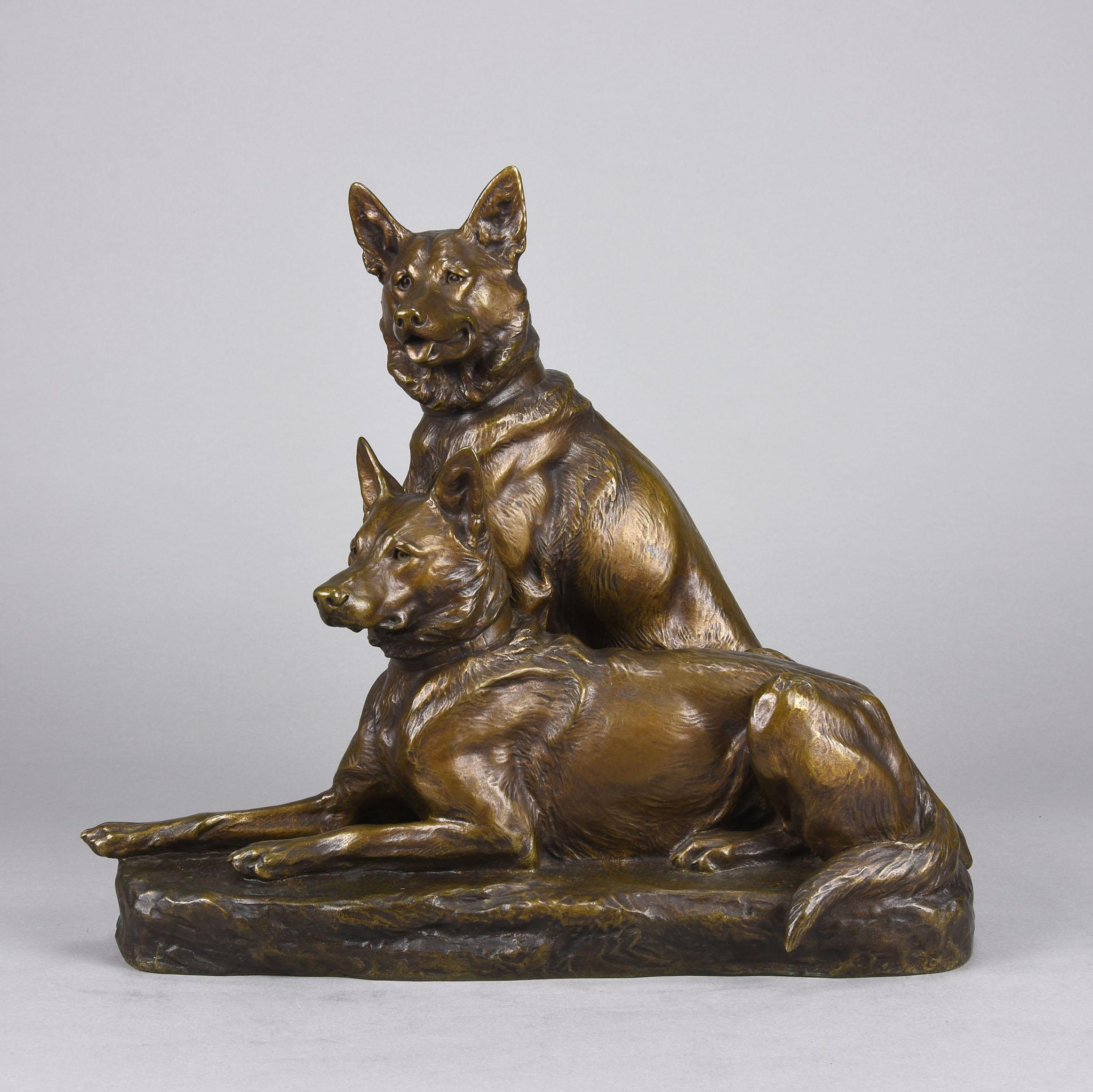 A fabulous French Animalier gilt bronze group of two Alsatians, one seated in alert pose with its head turned slightly and ears pricked whilst the other one lays in an alert pose. The surface with excellent naturalistic detail and very fine colour,