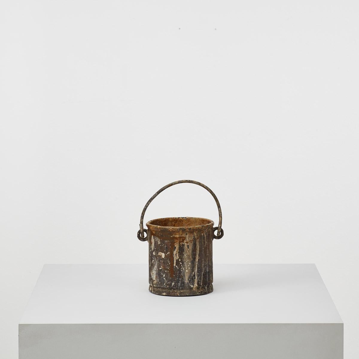 A cherished artefact. This early 20th Century antique artist’s paint pot is a nostalgic relic from a time when traditional tools fuelled artistic expression. Crafted from metal, the pot has withstood the test of time and bears marks and dints in