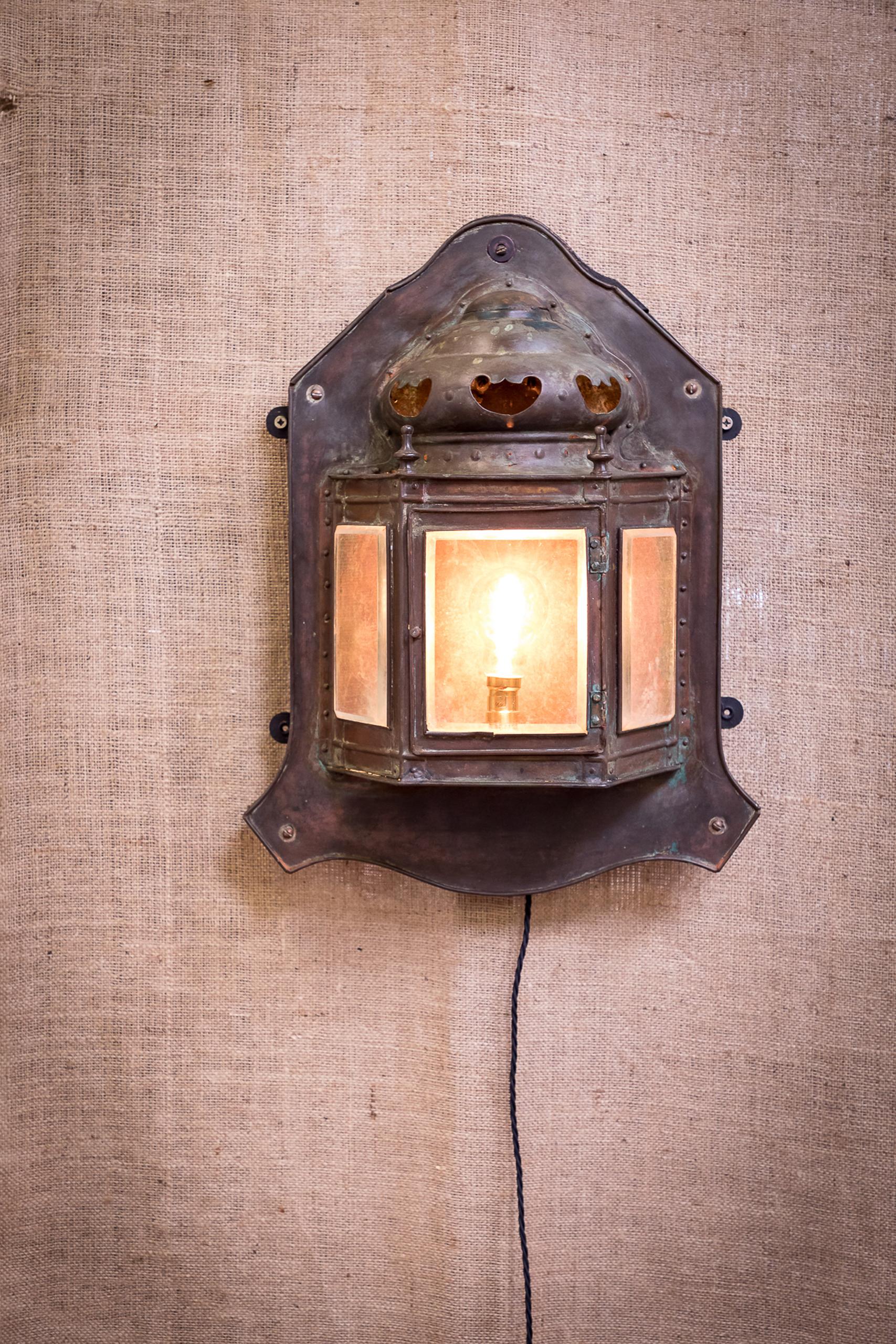 A beautiful copper wall light dating to the early 20th century.
This copper wall lantern has been fully restored, rewired and PAT tested.
The light has a central glazed door for access to the bulb and electrical fittings flanked by two further