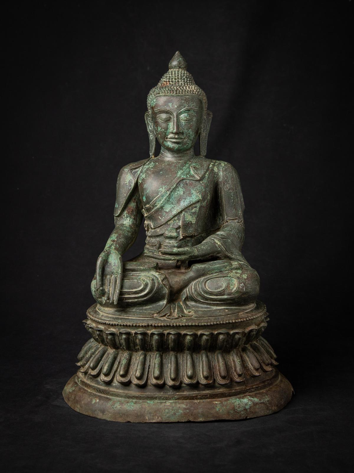Plongez dans la grandeur sereine de cette statue de Bouddha birman en bronze ancien, un chef-d'œuvre du début du XXe siècle provenant de Birmanie (Myanmar) qui incarne la grâce spirituelle et l'excellence artistique du style Amarapura. D'une hauteur