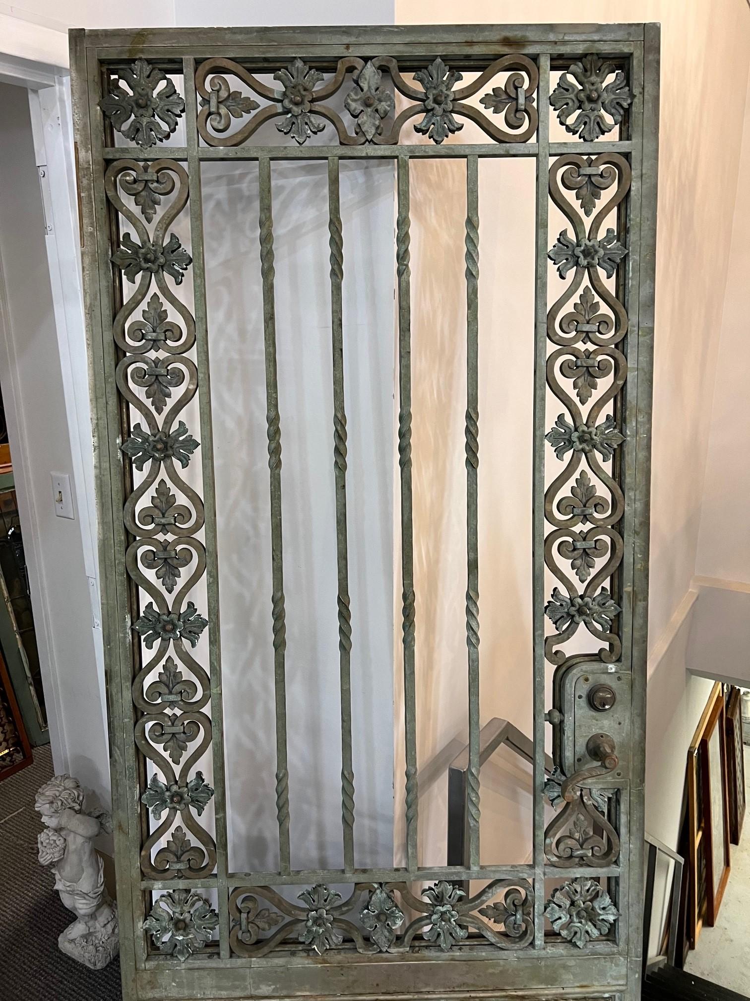 Porte ou portail extérieur en bronze du début du 20e siècle avec de beaux détails des deux côtés. La vitre est manquante sur le panneau montré sur la photo mais pourrait être facilement remplacée. Avec le panneau en verre, cette porte ferait une