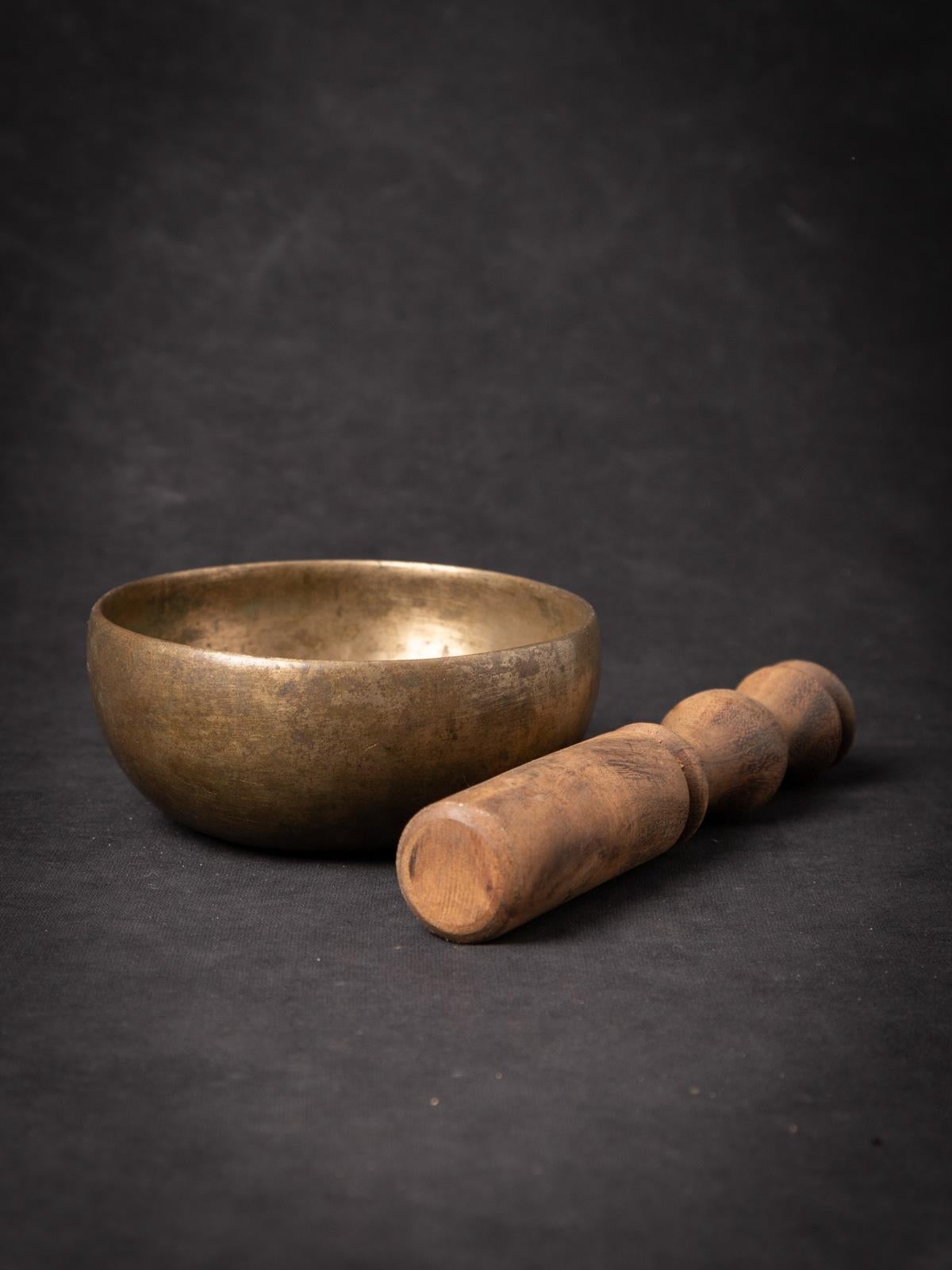 The antique bronze Nepali Singing Bowl is a fascinating and historically significant artifact originating from Nepal. Crafted from bronze, this singing bowl stands at 5.4 cm in height and has a diameter of 12.5 cm. Dating back to the early 20th