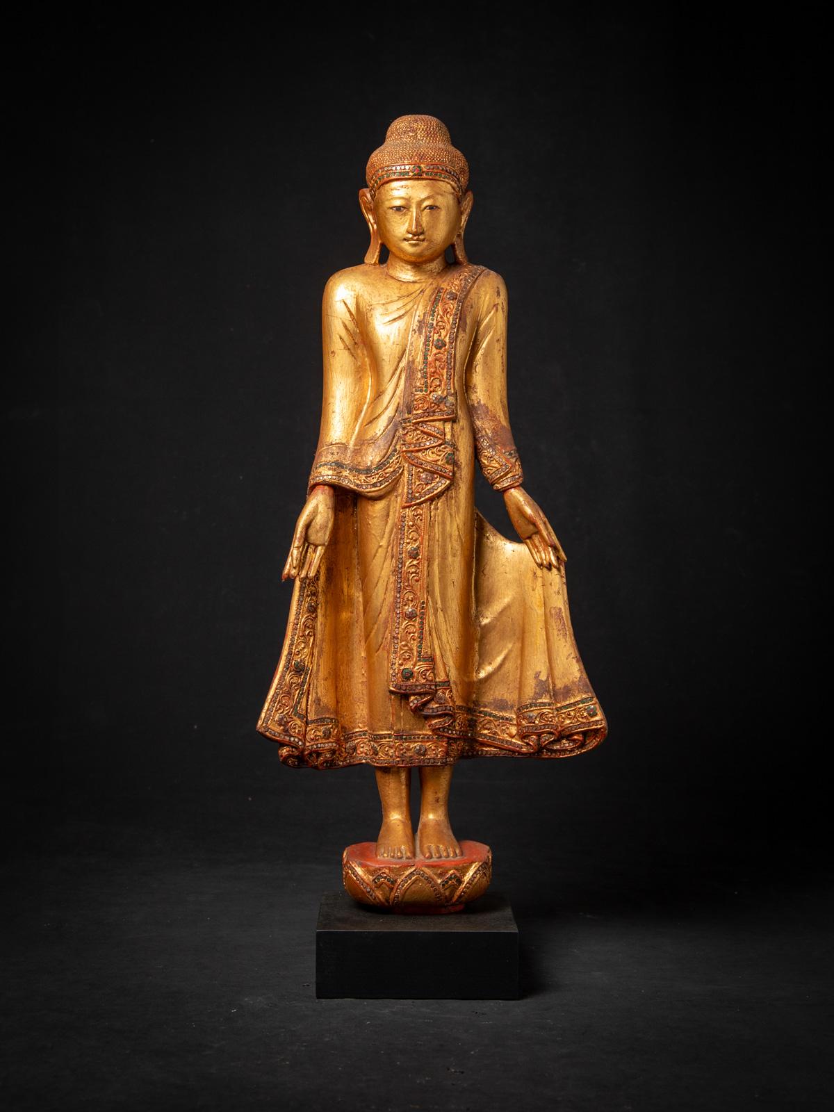 Cette statue antique de Bouddha birman de Mandalay est une belle représentation de l'artisanat birman du début du XXe siècle dans le célèbre style de Mandalay. Sculptée dans du bois et richement dorée à l'or 24 carats, la statue mesure 89,5 cm de
