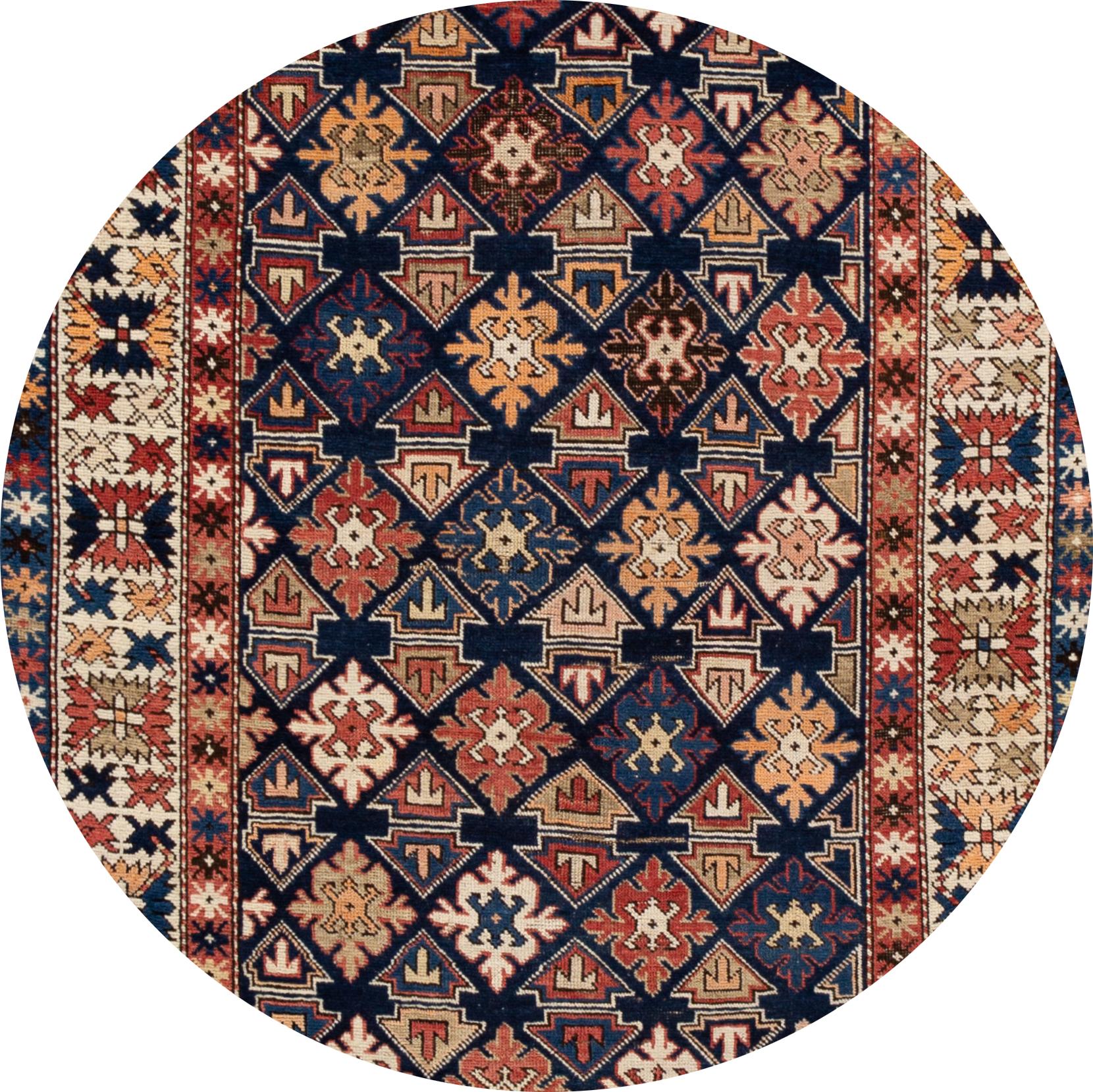 Magnifique tapis ancien du Caucase, en laine nouée à la main, avec un champ bleu marine et des accents multicolores dans un motif géométrique, vers 1910.
Ce tapis mesure 3' 9