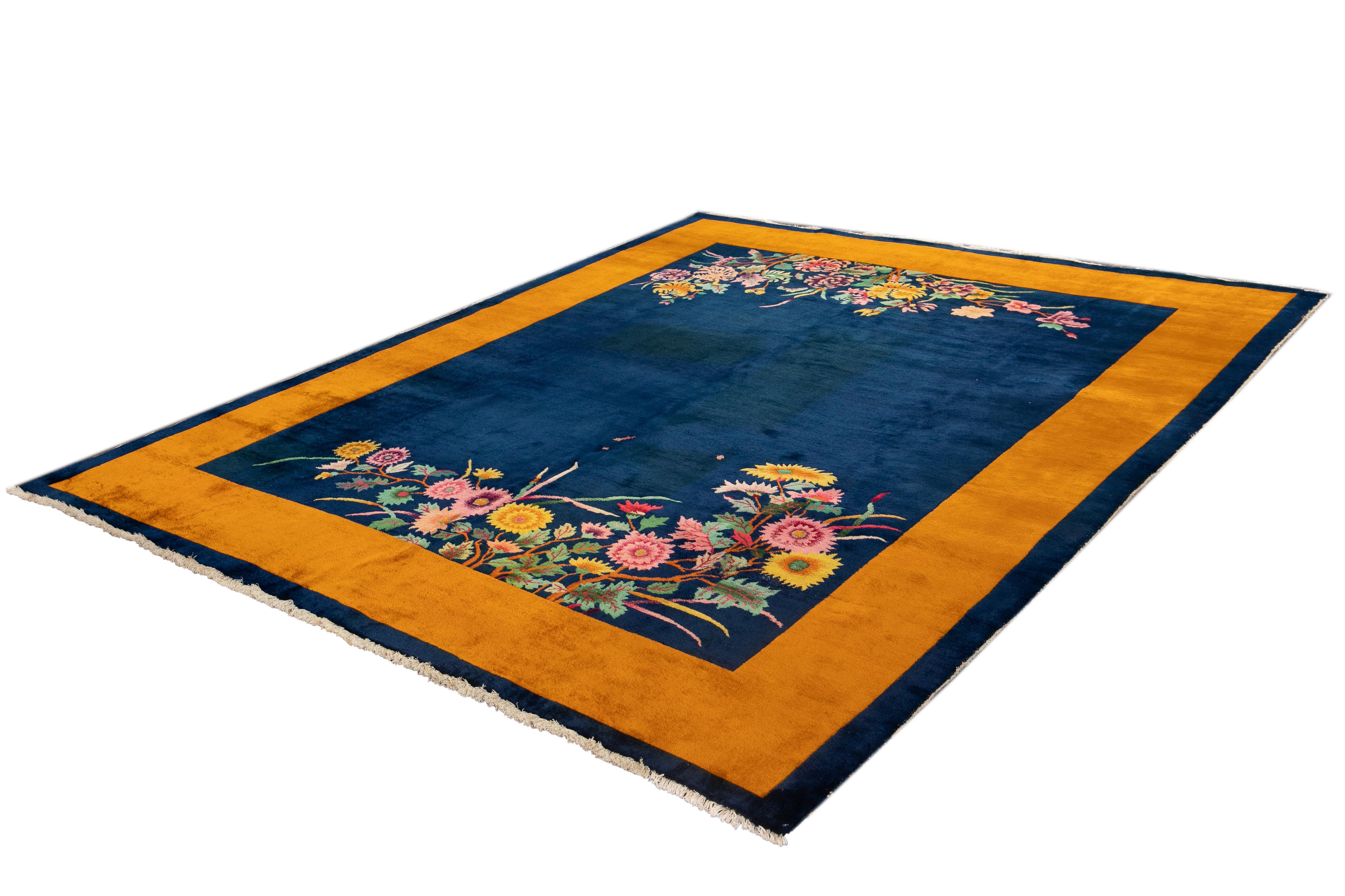 Beautiful vintage Chinese Art Deco rug with a blue field and gold border with multicolored accents and floral designs. 

This rug measures 8' 2