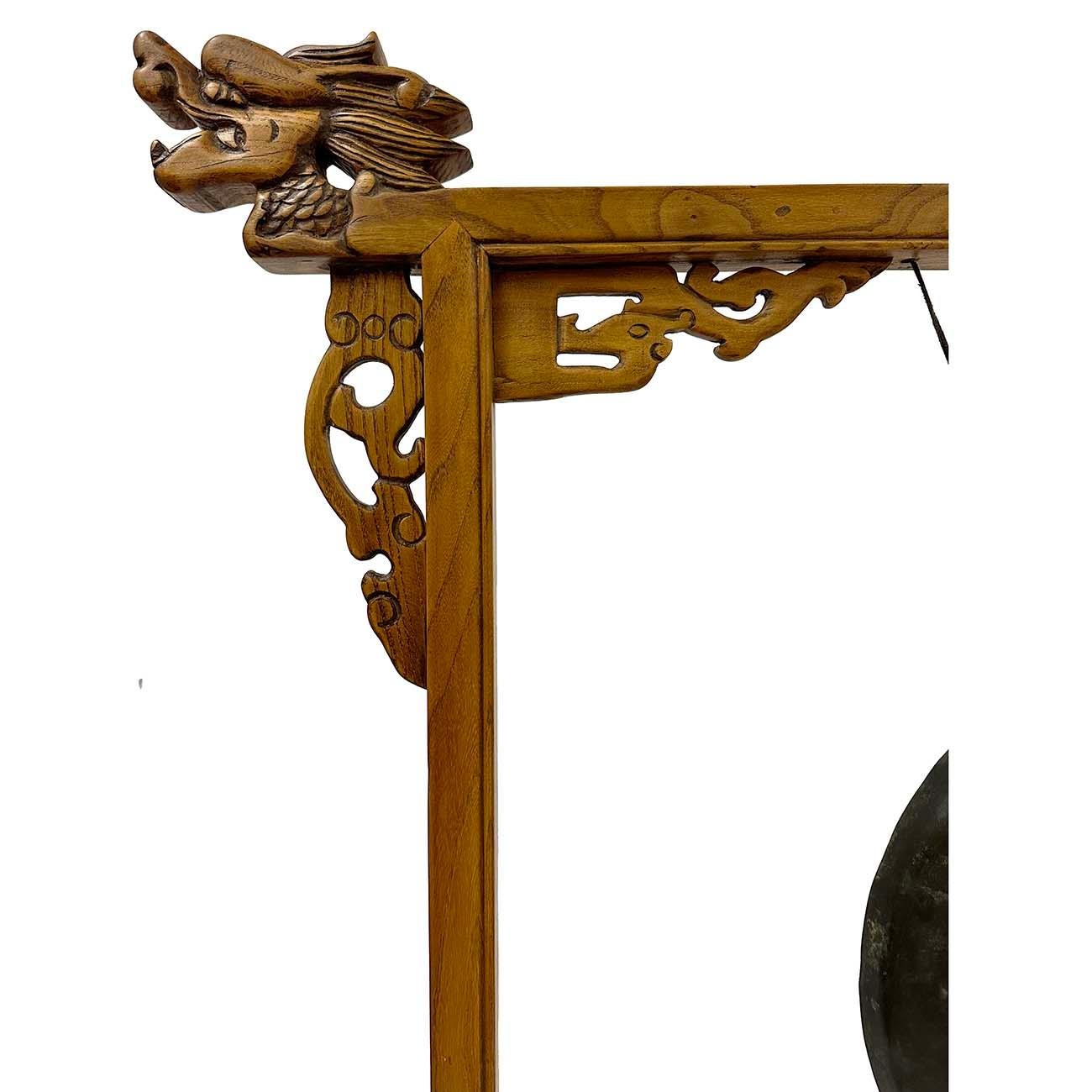 This antique Chinese table gong is hanging on a carved wood stand. It features beautiful carved fretwork on the bottom and detailed carving work of decorated dragons on the top of the wood frame. This antique gong is 100% hand made. Overall this