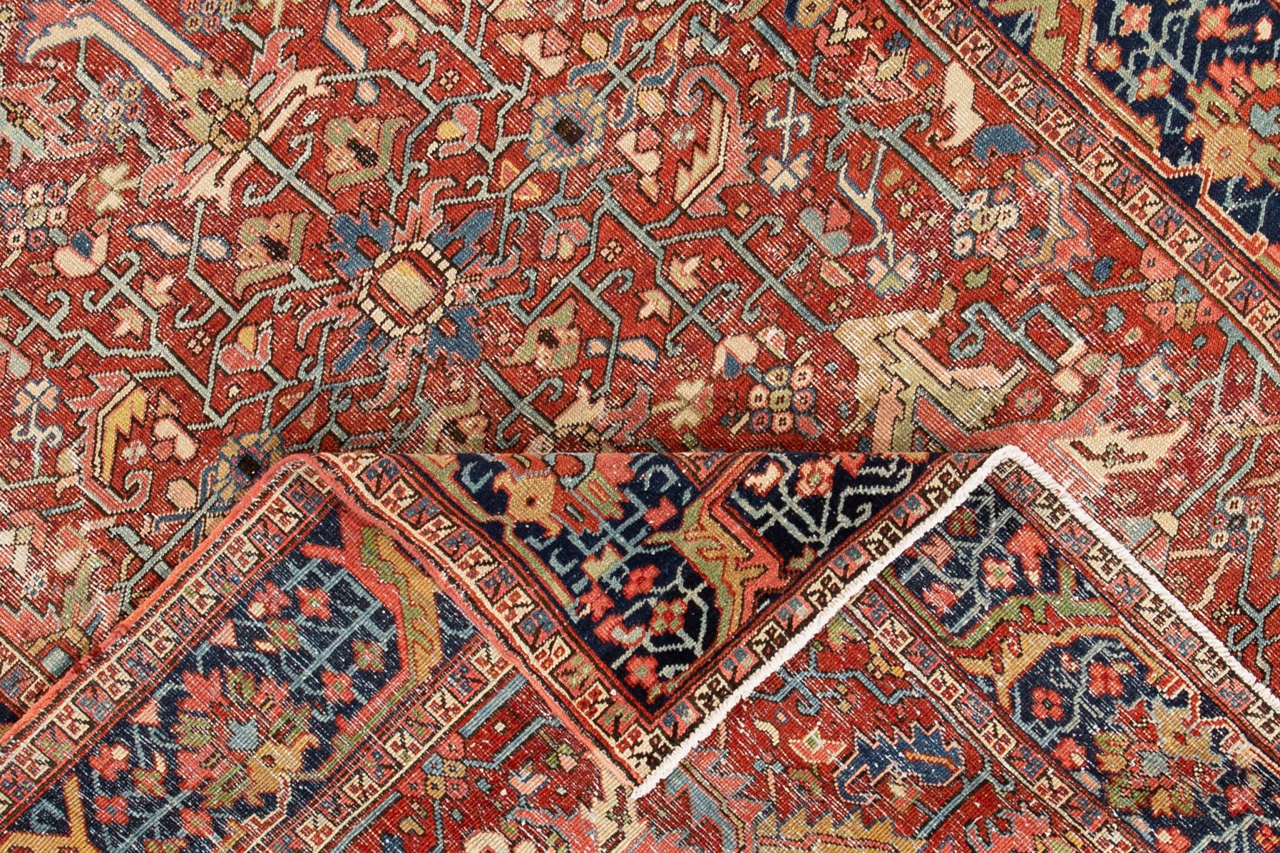 Beautiful hand knotted vintage Persian Heriz wool rug with a red field and a black border. This rug features multicolored accents with an all-over floral design,

circa 1920

This rug measures 6' 10