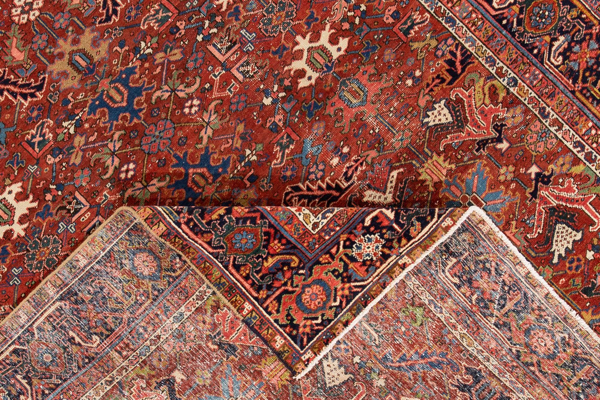 Beautiful hand knotted vintage Persian Heriz wool rug. This rug has a red field with an all-over multicolored floral design,

circa 1920

This rug measures 7' 6