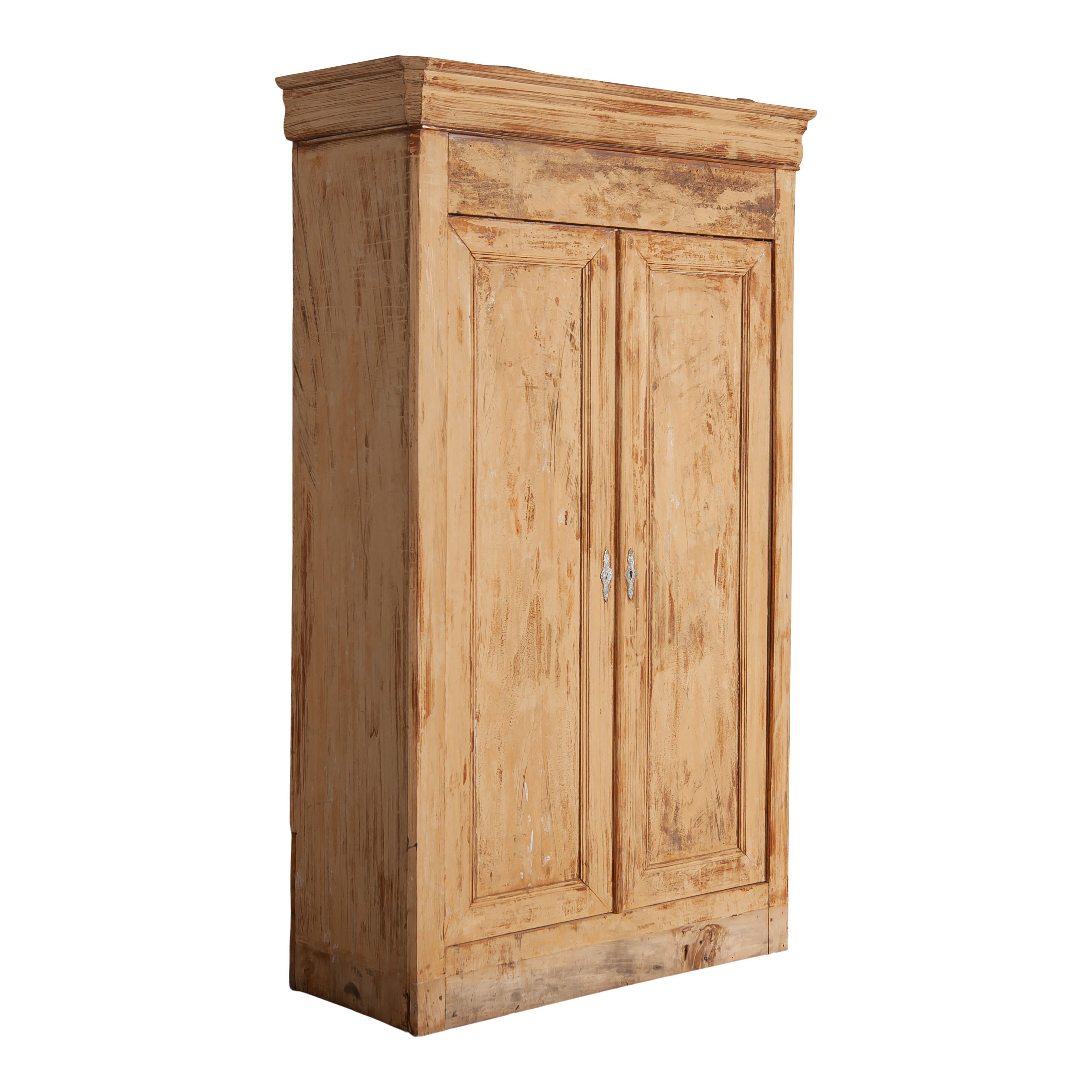 Antique French armoire with two large doors and three shelves. The light wood of this piece is worn and has a beautiful patina. This inside is painted black and features three shelves and plenty of storage. The classic and simply timeless details