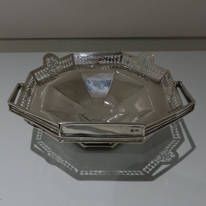 A stylish early 20th century silver octagonal designed swing handled cake basket. The upper bowl has an elegant ornate hand pierced galleried border for decorative highlights and the foot is raised pedestal.

 

Measures: Weight 17.8 troy
