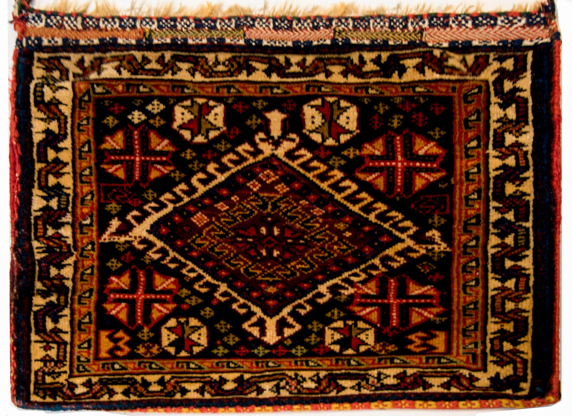 Un fantastique sac de berger persan Ghashgaei du début du 20e siècle, avec un magnifique motif tribal contenant un grand diamant en or au milieu d'un champ de fleurs stylisées, sur un fond de laine marron. La sangle est toujours intacte.