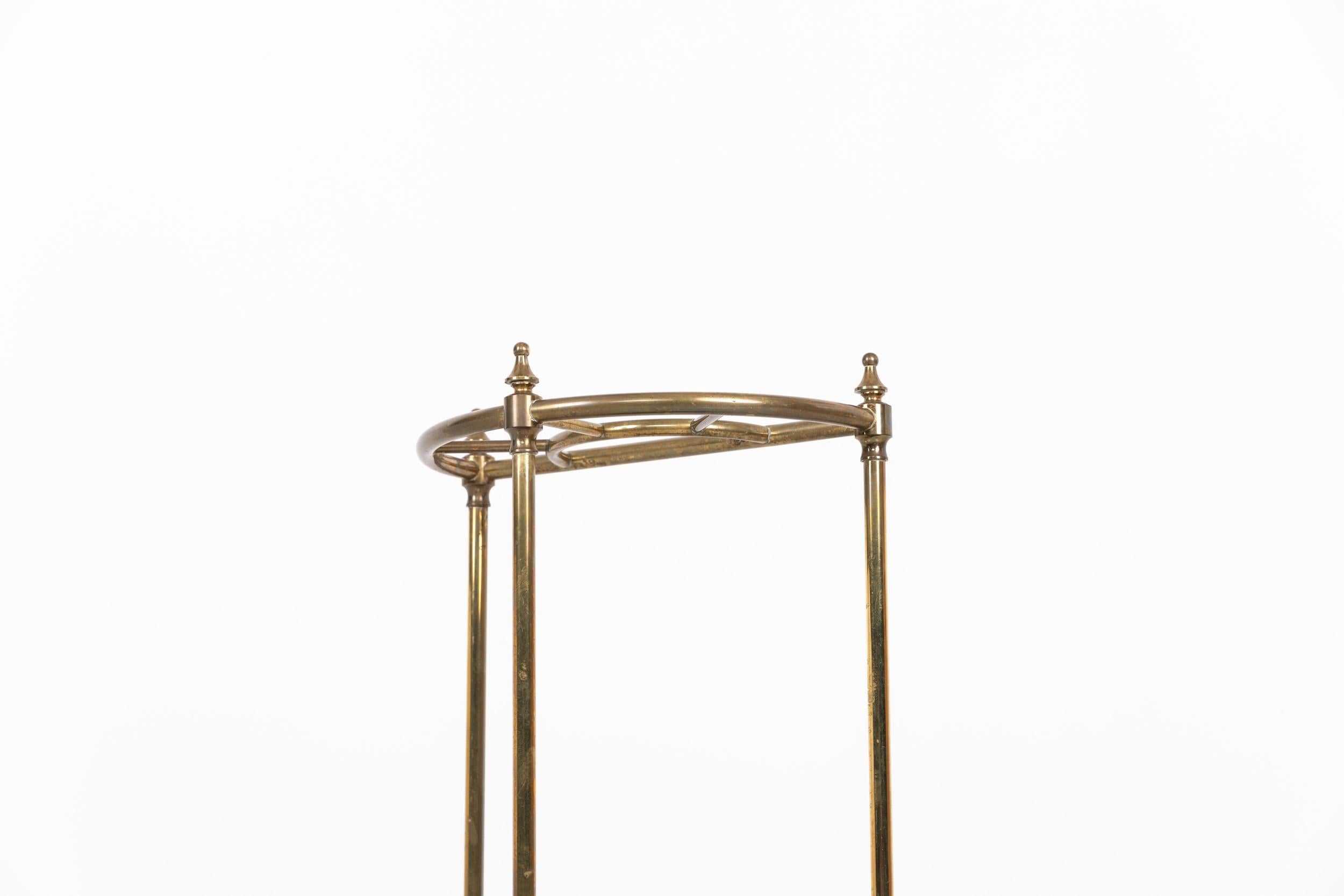 

An elegantly formed semi-circular Edwardian brass umbrella stand. c.1910

Cast iron base, with brass uprights and dividers, usually positioned in a hallway for storing umbrellas and walking sticks. Stylish and functional country house antique full