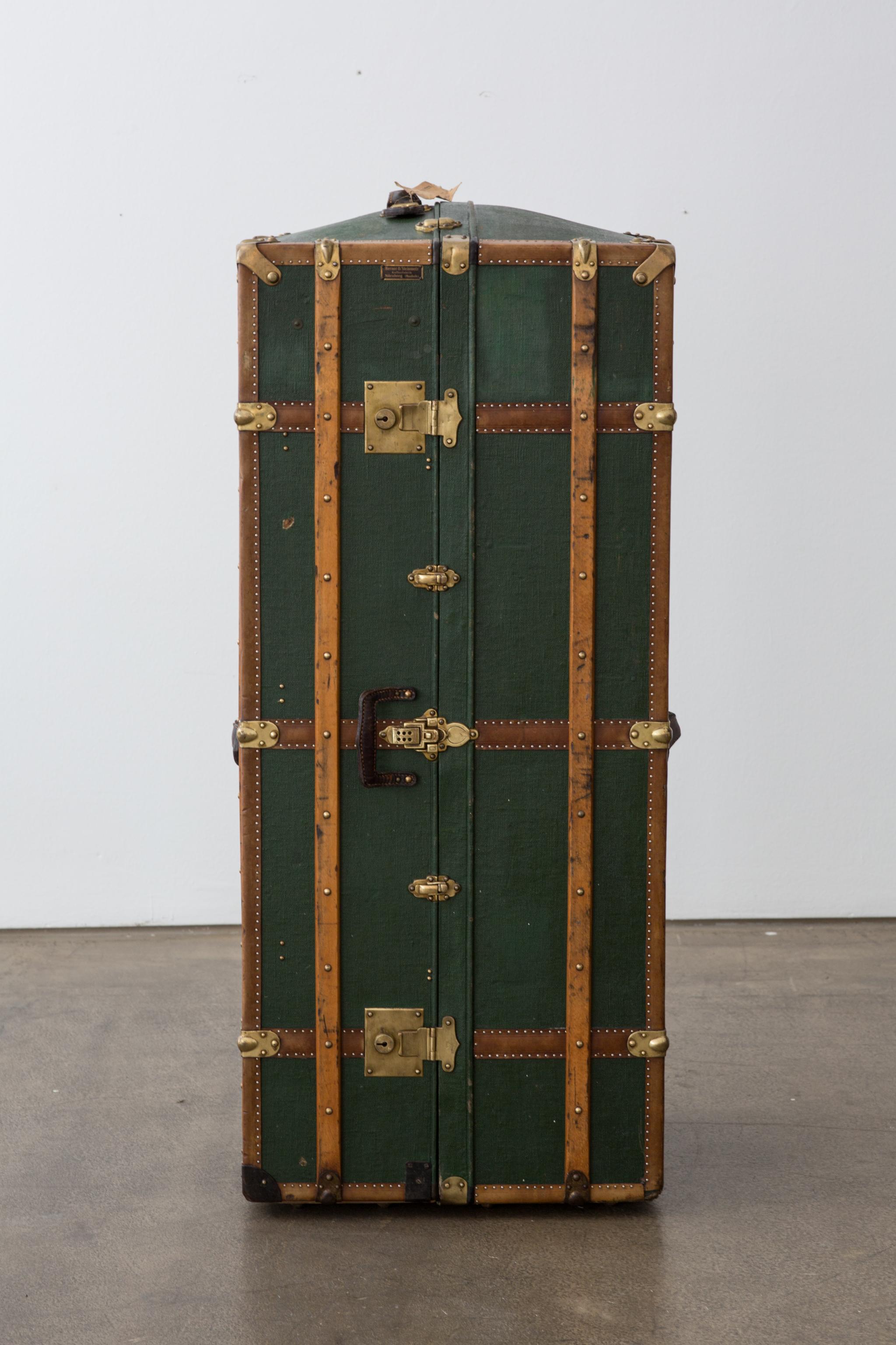 A very elegant and hard to find early 20th century (about 1920) wardrobe steamer trunk in wonderful green canvas. The inside is lined with purple fabric, which along with the green canvas and the brown leather makes for an intriguing combination.
On