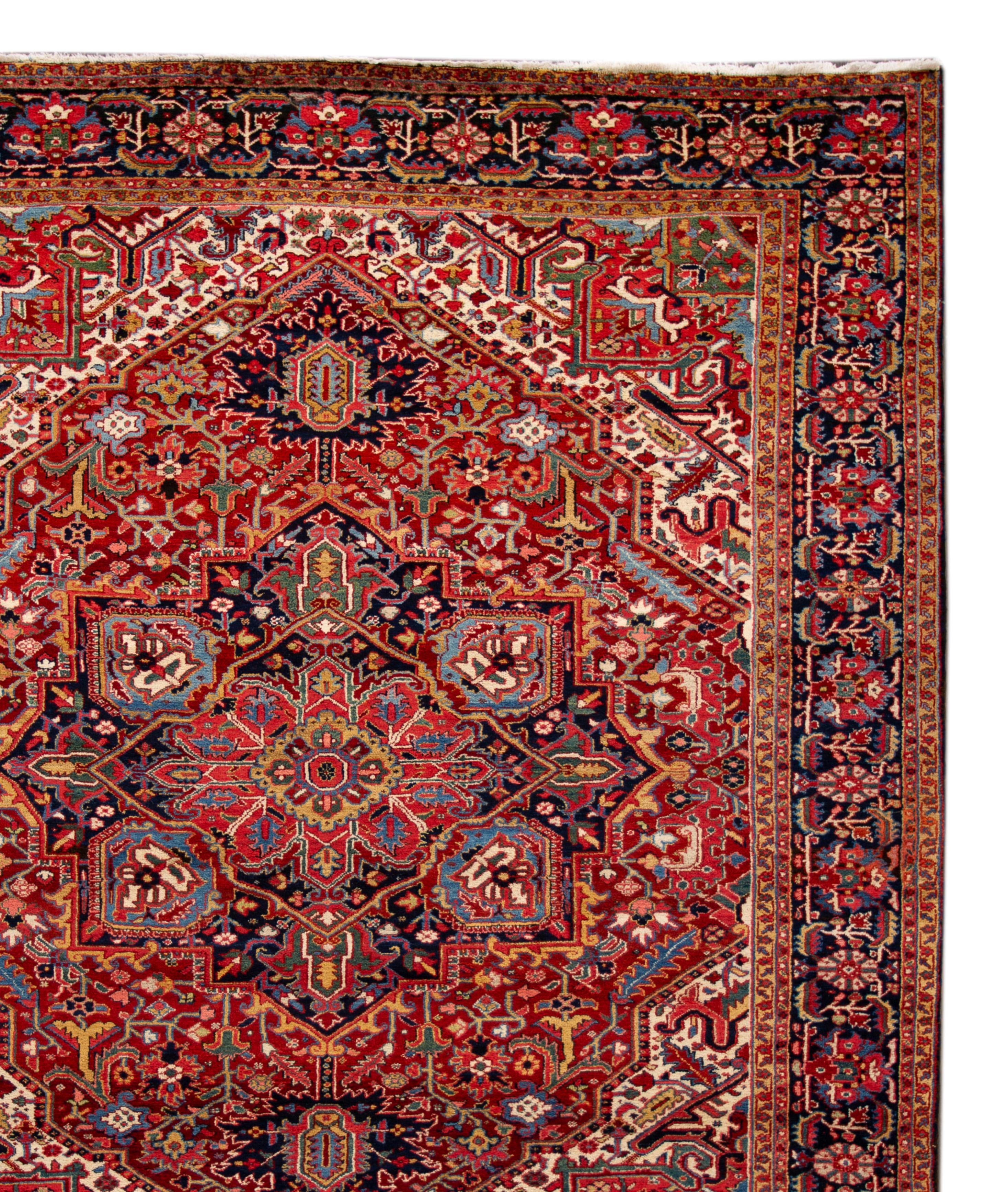Beautiful vintage Heriz wool rug with a red field and blue accents with an all-over medallion design. Measures: 9'2