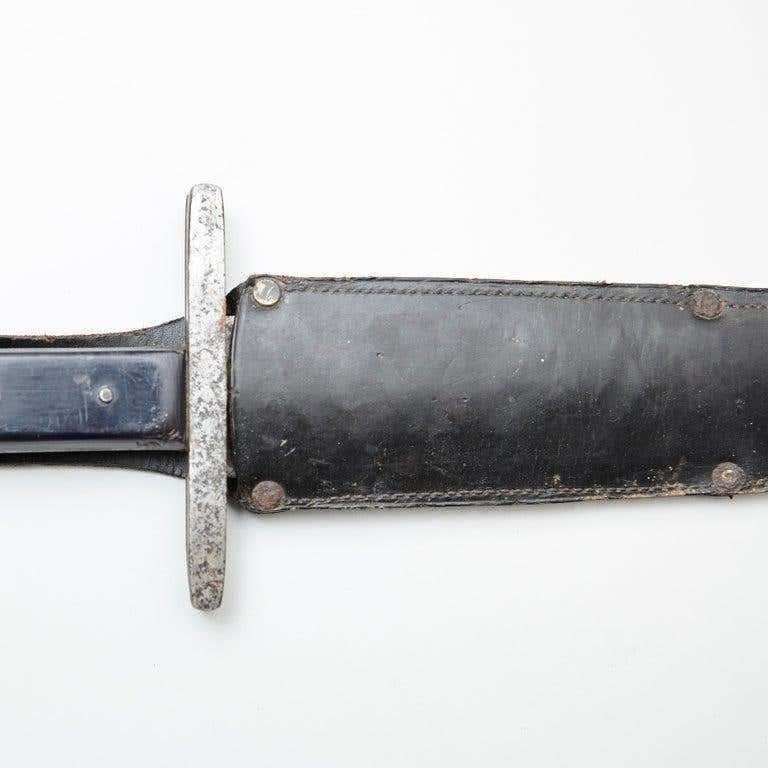 Early 20th century antique hunter knife with leather case.  By unknown artisan from Spain.    In original condition, with minor wear consistent with age and use, preserving a beautiful patina.     Materials:  metal  leather    Dimensions:  D 2 cm x
