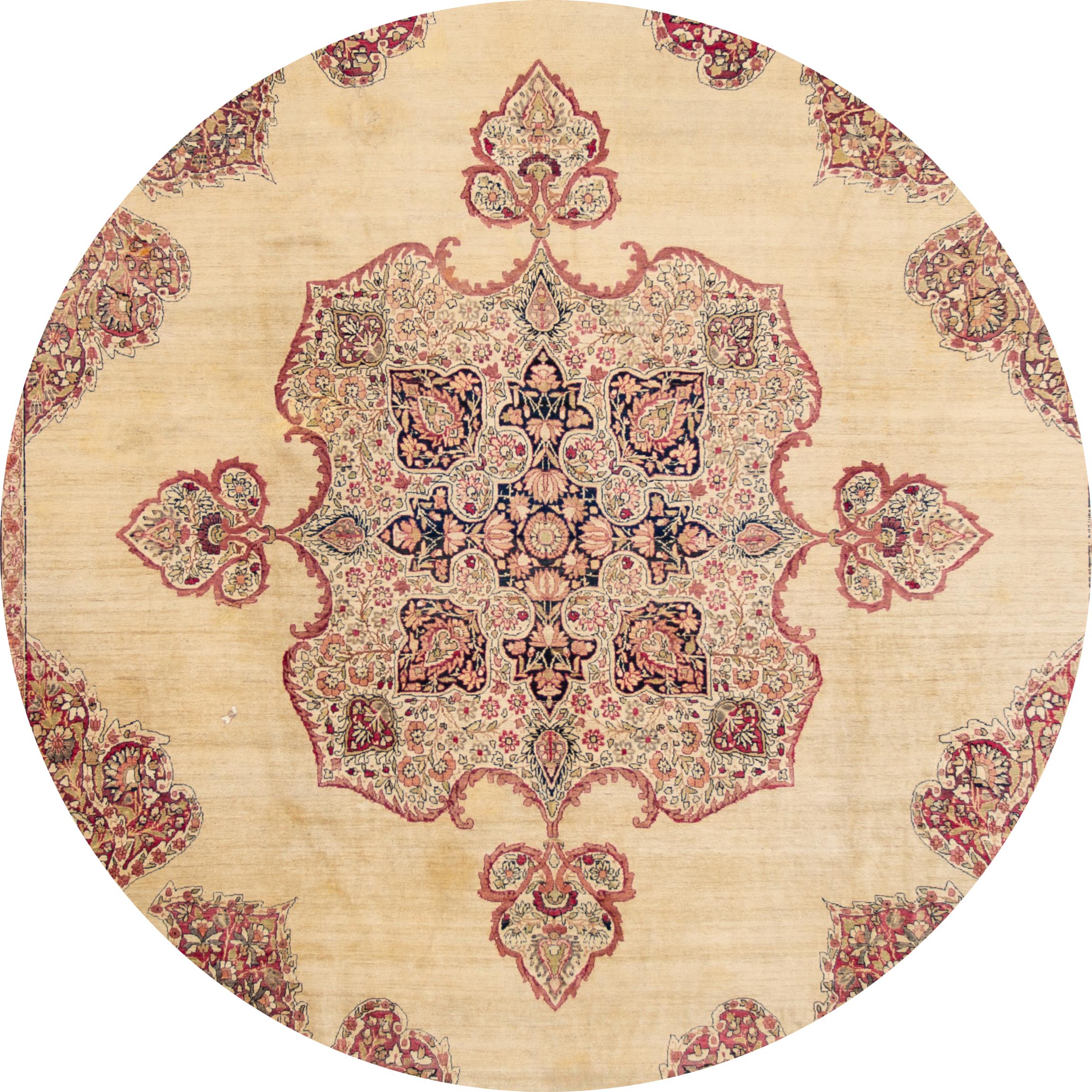 Beautiful antique Kerman rug, hand knotted wool with a pink field, tan and ivory accents in a center floral medallion design, circa 1920.
This rug measures 10' 10