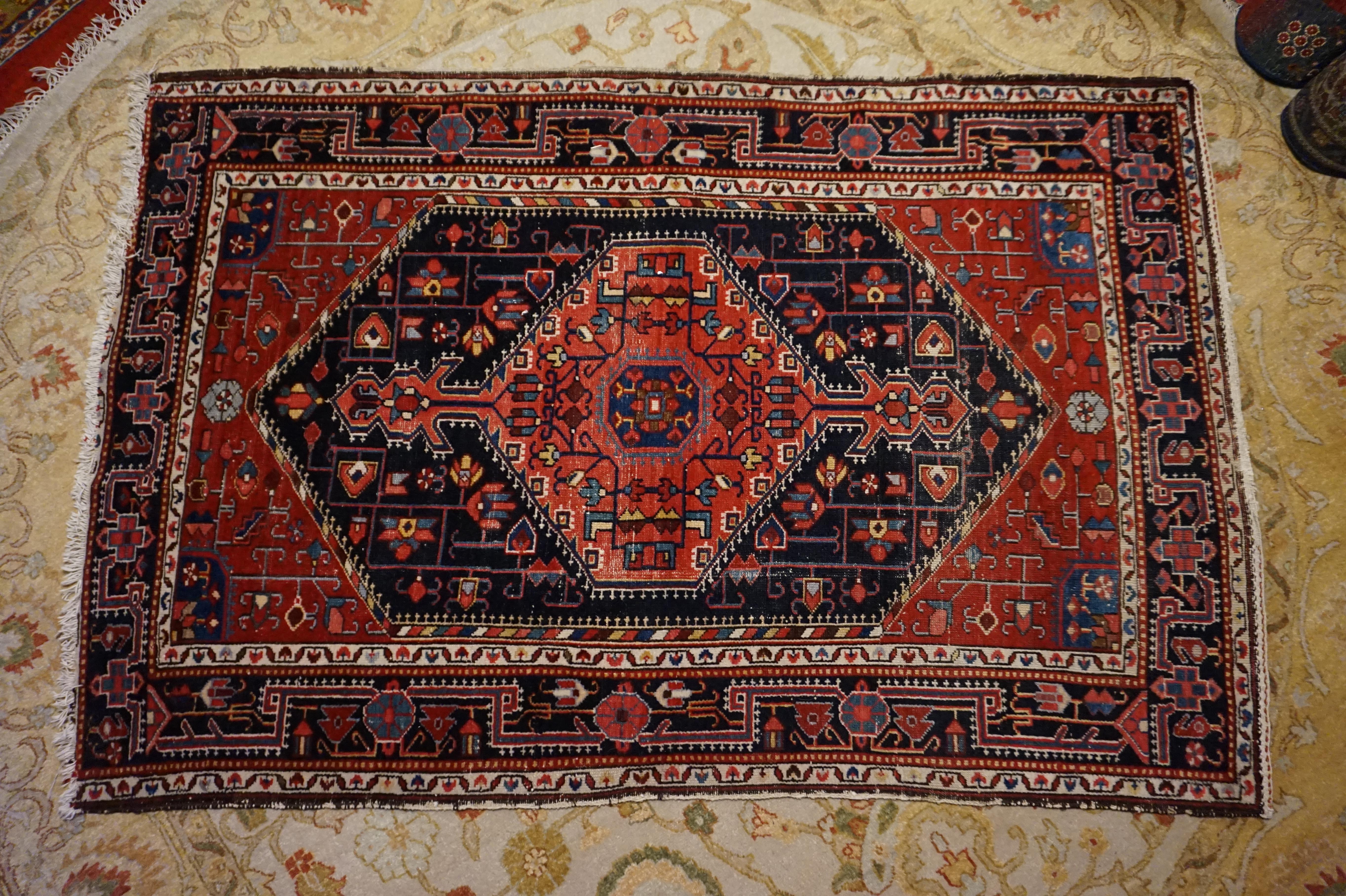 A lovely medley of warm colours and bold tribal pattern highlight this beautifully hand knotted rug. The rug showcases geometric themes with kite medallion and floral patterns in rich reds contrasted with black borders. It makes a statement when