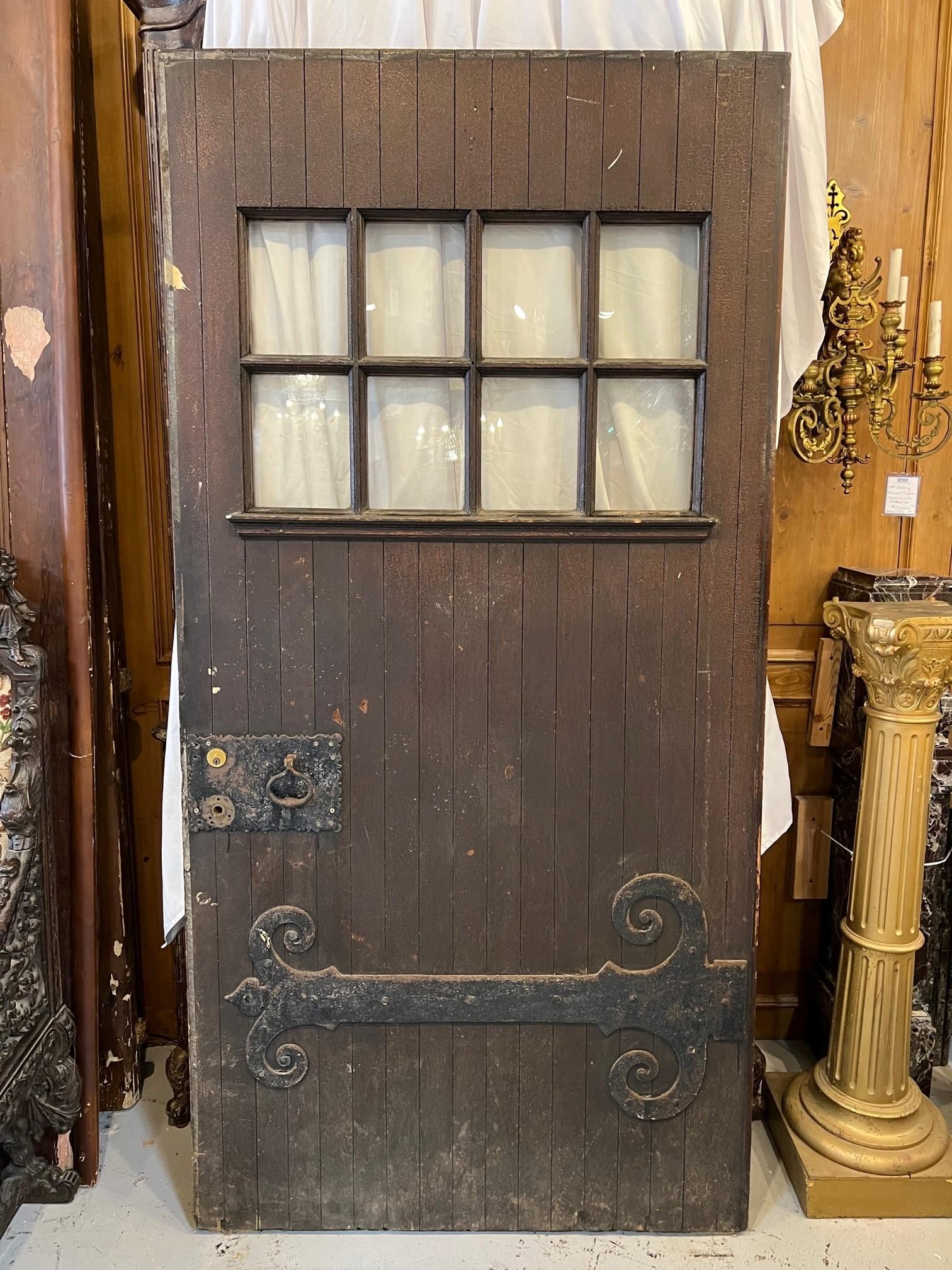 Early 20th century antique oversized door with large iron hinge and eight small windows. This is a great door 42' x 84