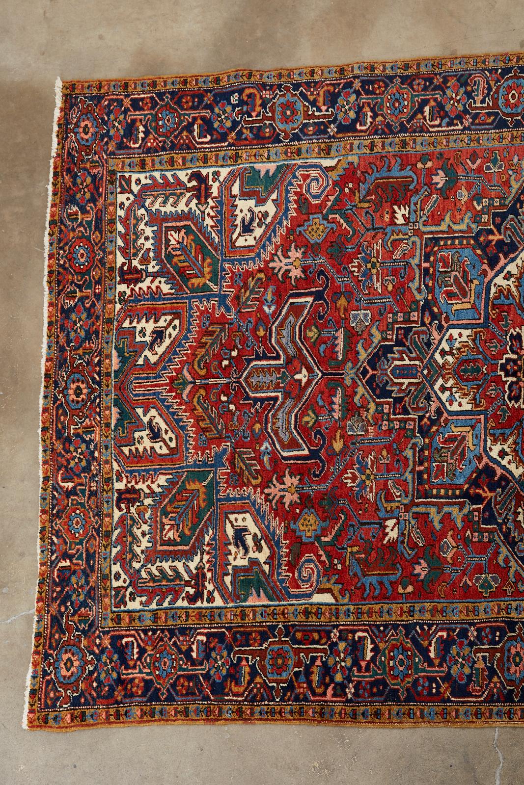 Classic early 20th century antique Persian rug crafted from hand-knotted wool over a cotton warp. The carpet was woven in the village of Heriz in Northwest Iran Azerbaijan province. Centered by a star shaped medallion having layers of designs. The