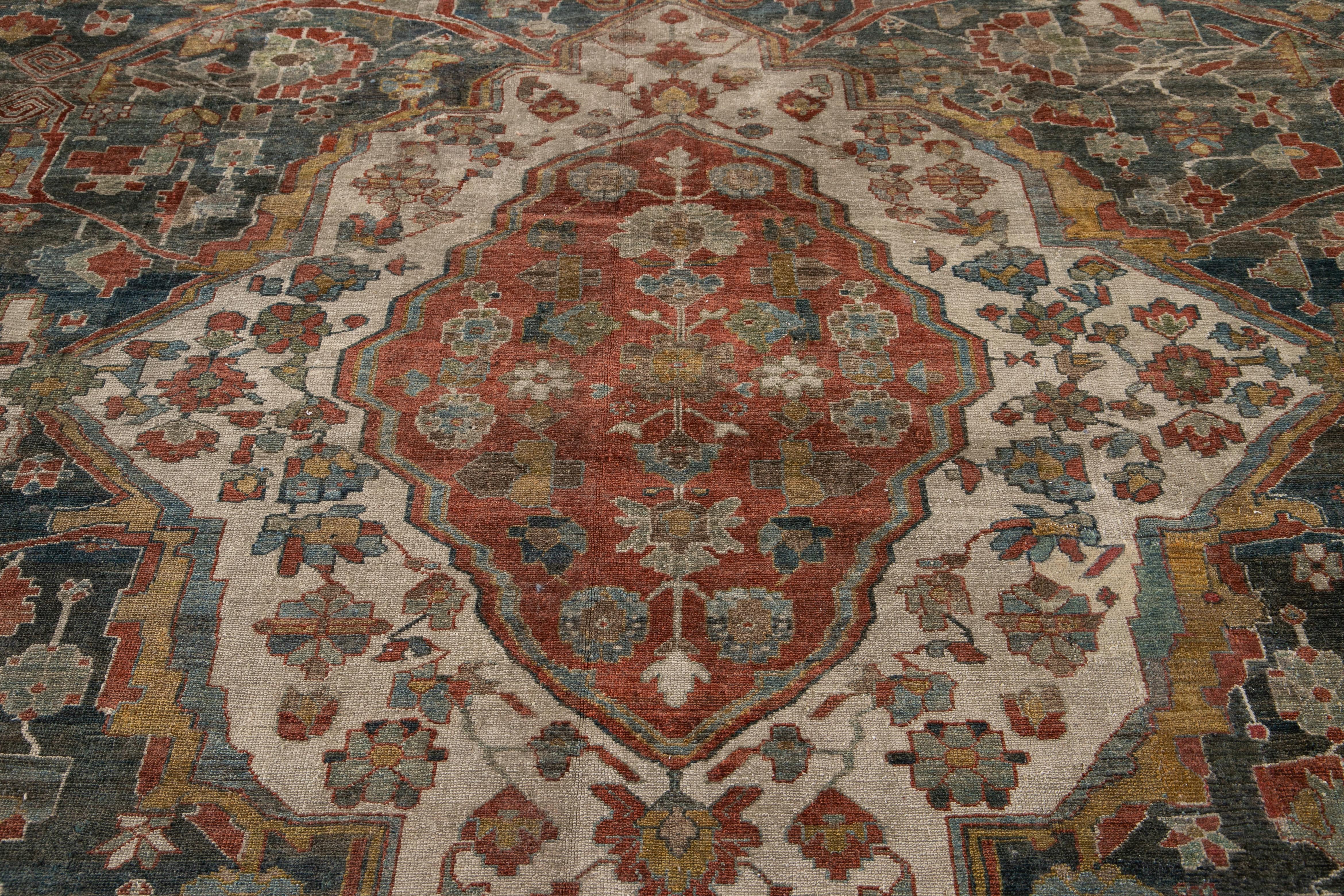 An early 20th century antique hand knotted Persian Malayer rug showcasing a central medallion design decorated with an all-over floral field. This rug comes from the city of Malayer located within the providence of Hamadan. This area in Iran has a