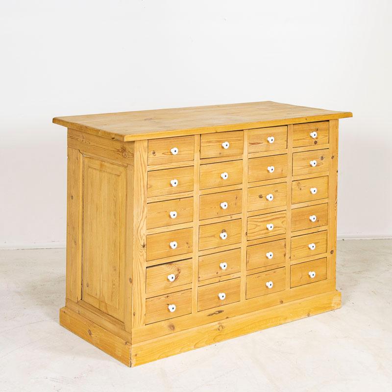 Fun and function abound in this free standing pine kitchen island with 24 drawers. This delightful pine apothecary originally served as a shop counter or storage cabinet. Counters similar to this were used throughout shops in the European