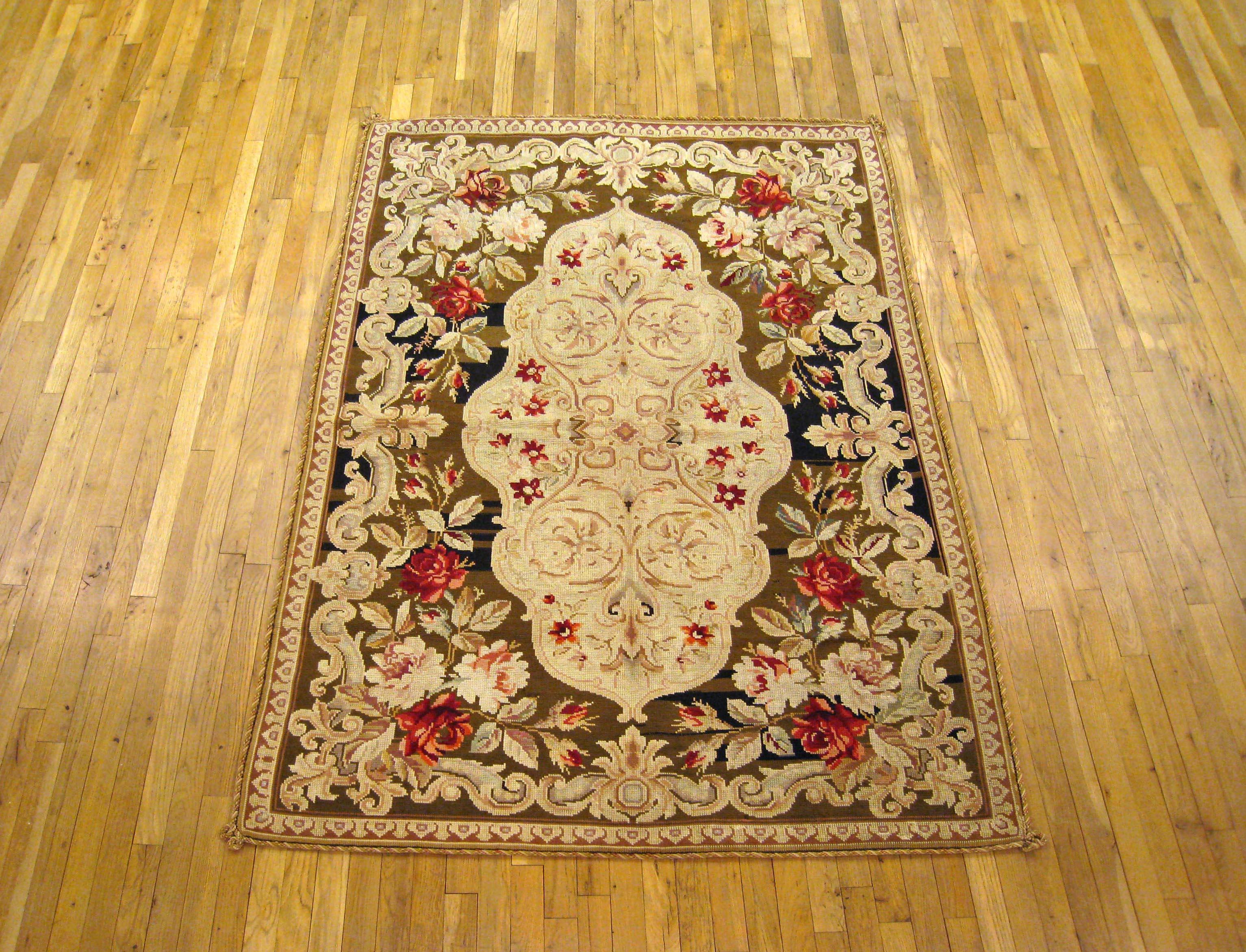Antique Portuguese needlepoint flat-weave rug handwoven with a symmetrical floral design, ivory center, and bold splashes of color in the border. Can be used as a wall hanging or a floor covering. Measures: 6'7