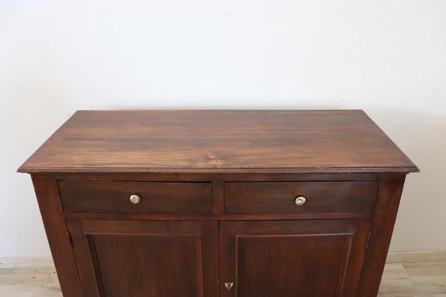 Beautiful antique solid walnut and poplar wood italian rustic buffet, early 20th century. Characterized by a simple and essential line. The fine wood has acquired a beautiful old patina. Equipped with two comfortable drawers. Internally equipped