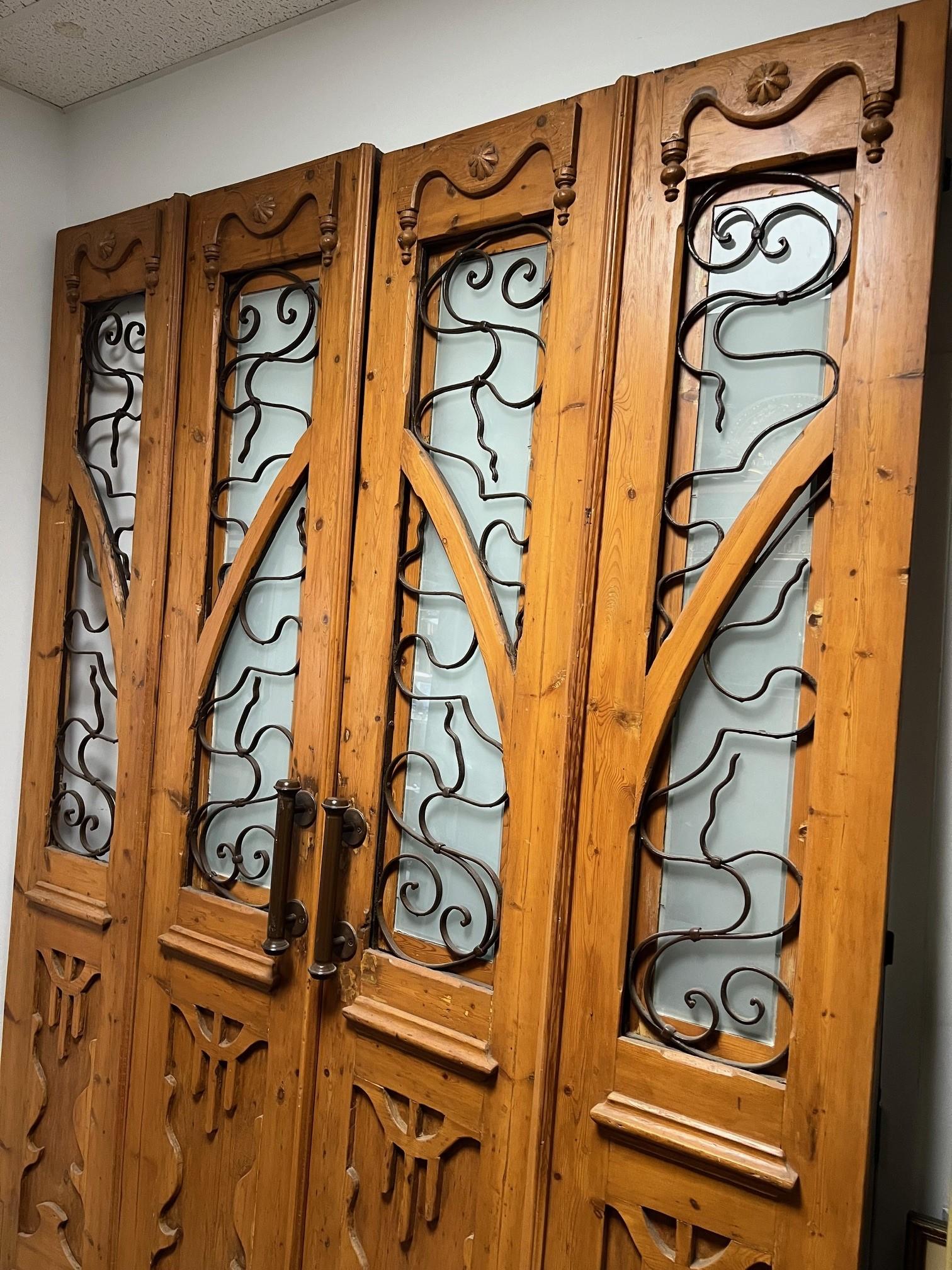 This is a great set of four antique doors wood with decorative iron panels. The set was imported from Egypt and were produced at a time in the early 1900s when French architecture and style had a great influence on the Egyptian culture, especially