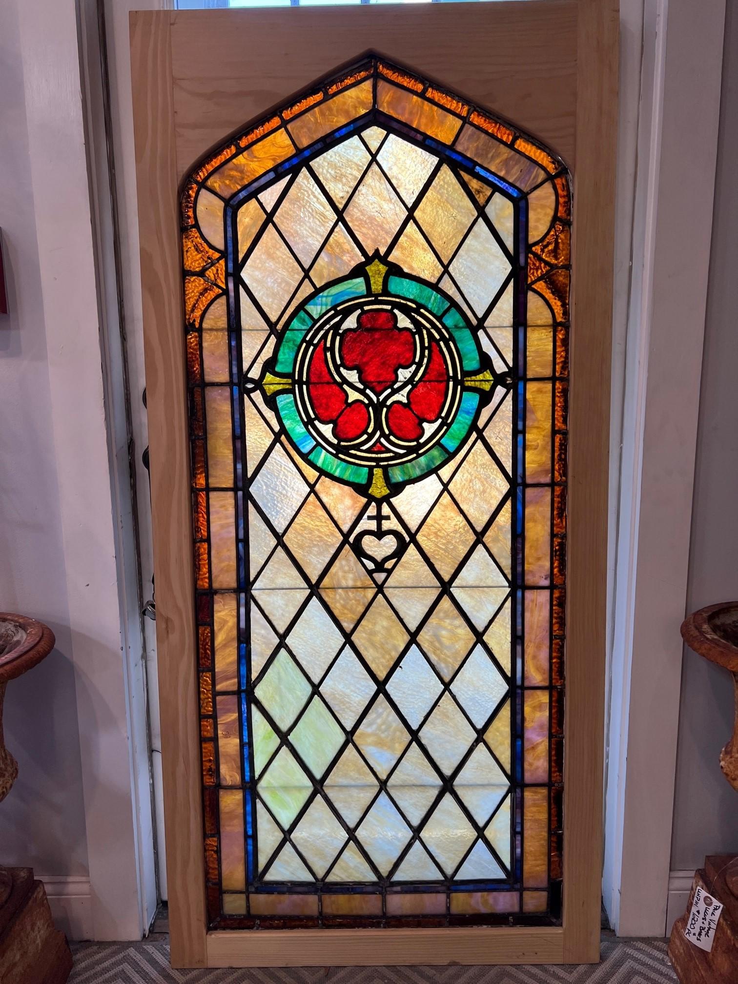 Early 20th century leaded stained glass window in a new wood frame. This is a great window with a deep red center which is beautiful in the sunlight. The window has a couple of small cracks shown in the photos but is in very good condition and