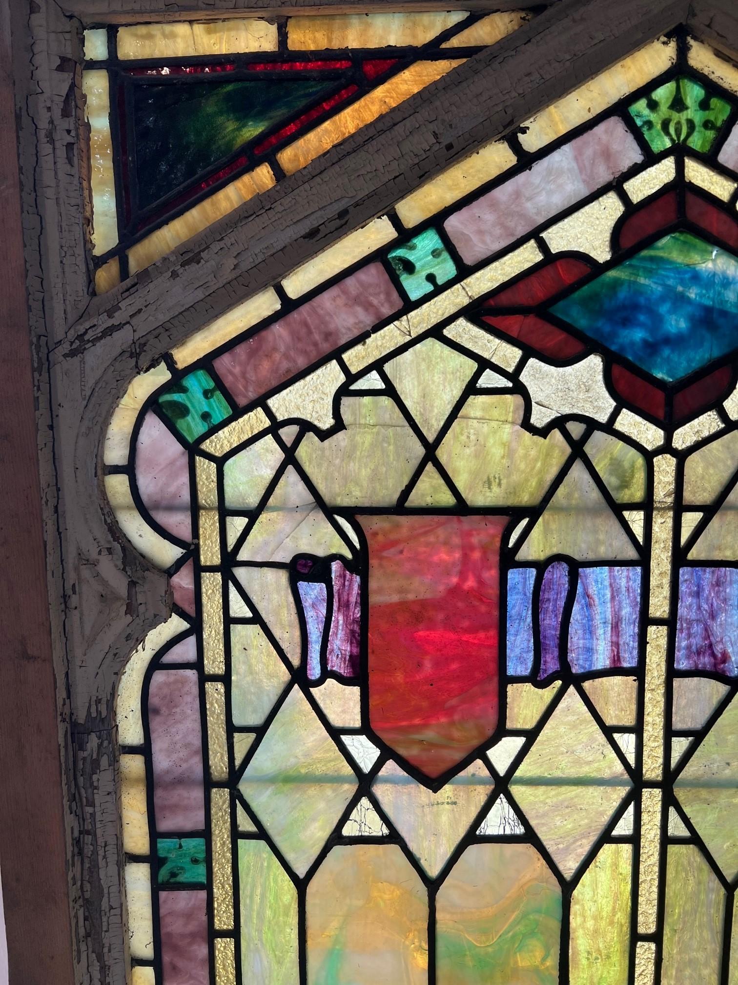 Early 20th Century stained glass window from a Tudor style estate in Pittsburgh PA. The colors of the glass are beautiful and it has a lower window that pulls opens. This is a great window that was salvaged from a demolition and would look great
