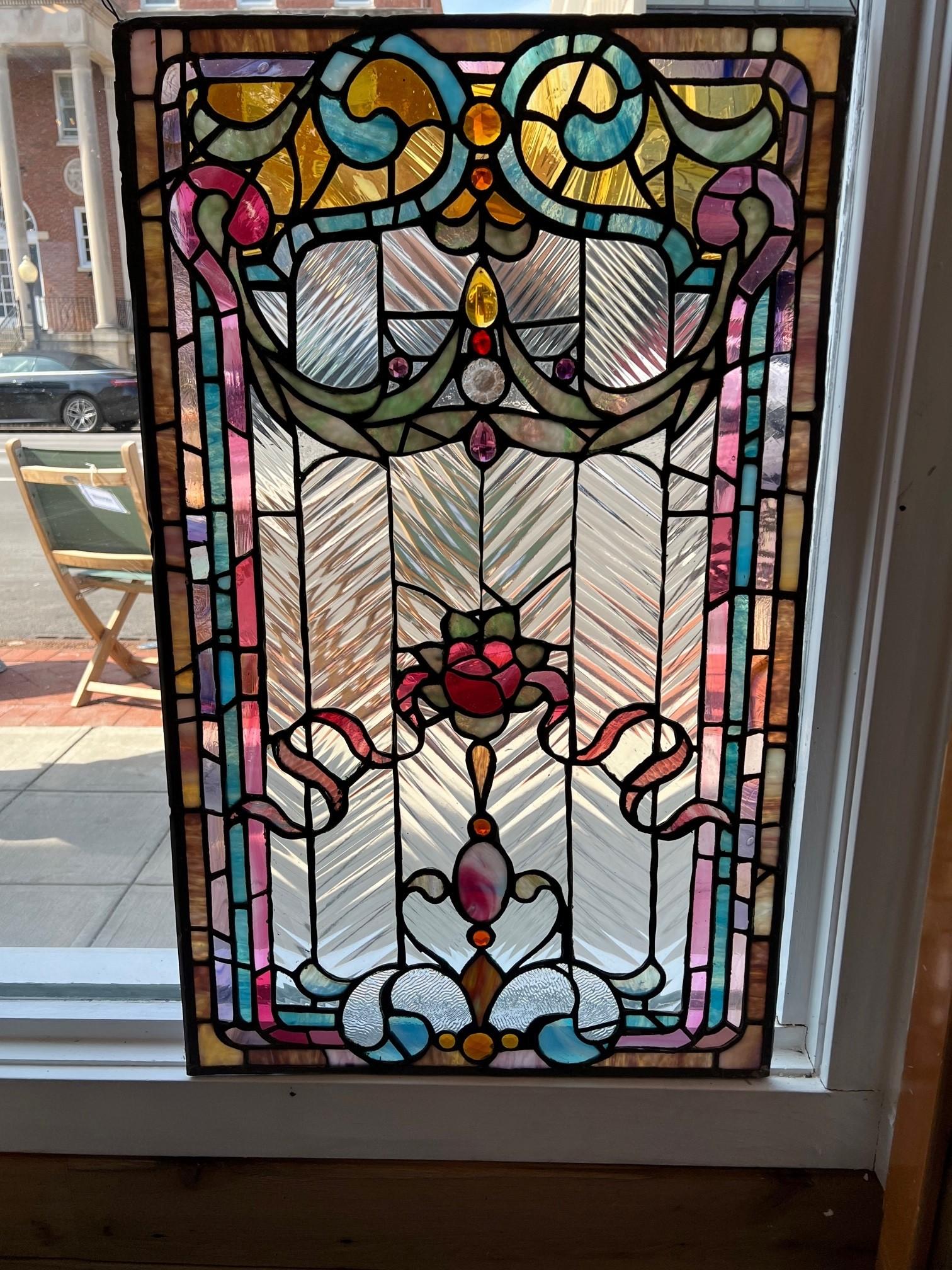 Early 20th century beautiful and very colorful antique stained glass window from a upstate New York estate. The window does not have a wood frame but hangs from two hooks in each corner. This window would look amazing in any room of the house when