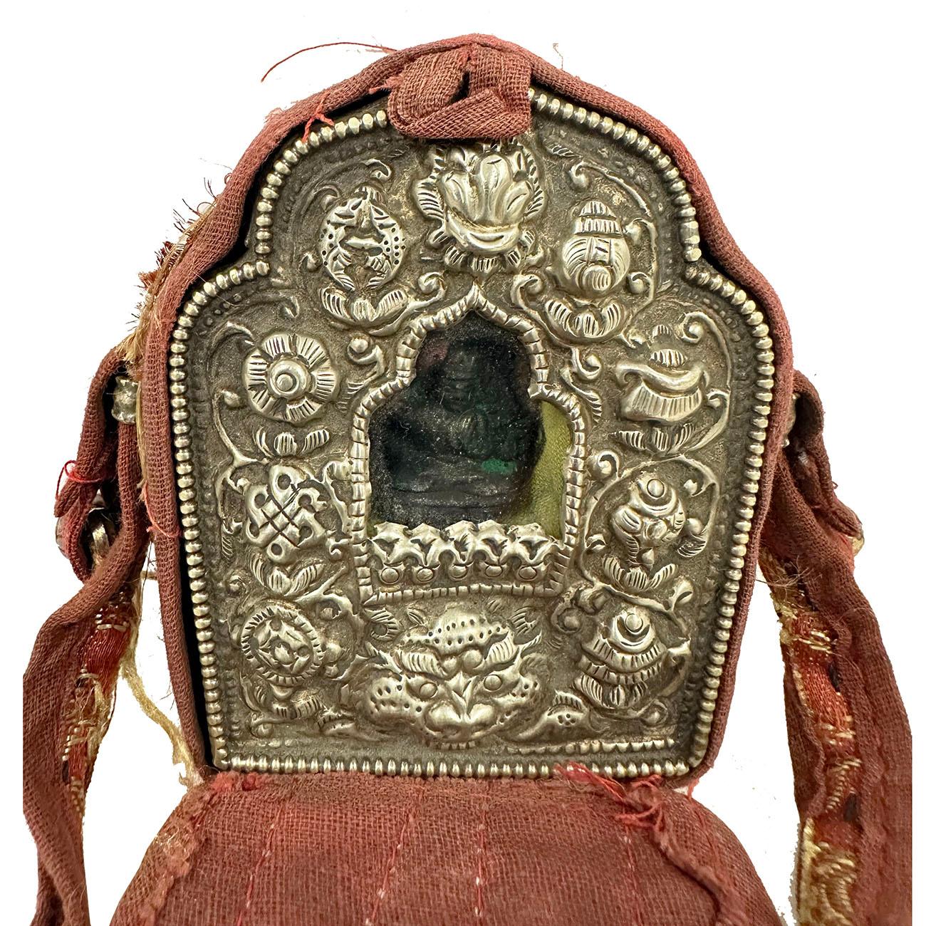 Ghau is a small prayer box worn as pendant by Buddhists as portable shrines which can be pray by prayer during their travel. This Ghau prayer box (travel Buddha shrine) made from Tibetan silver with a Buddha inside all wrapped in a hand embroidered
