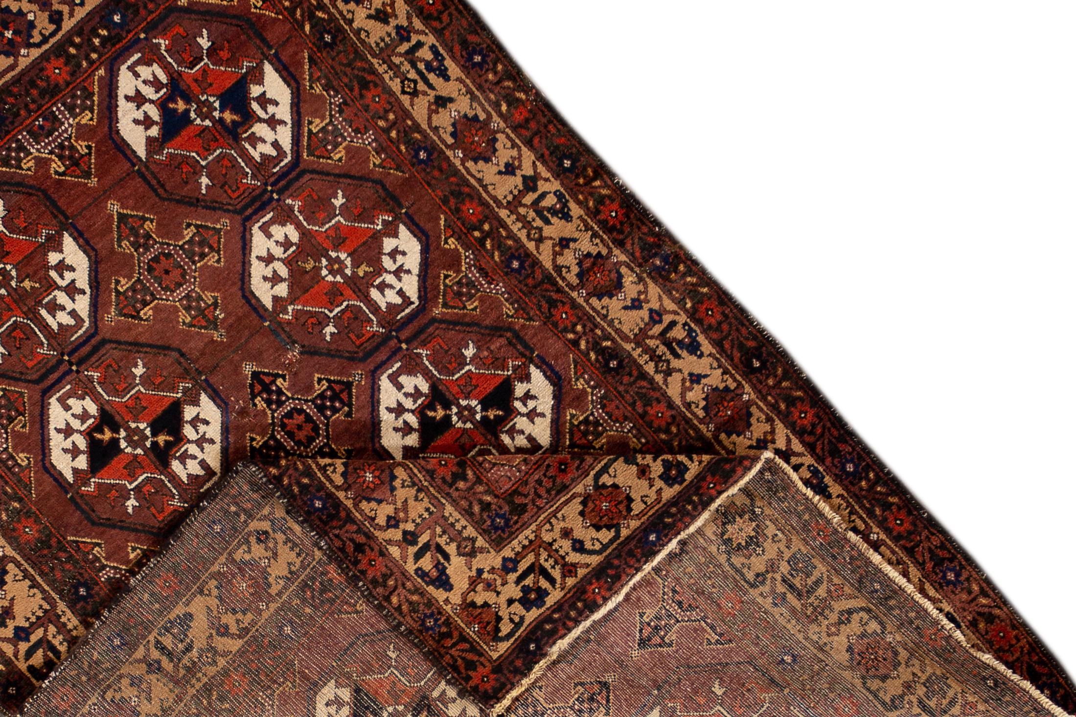 An early 20th century hand knotted antique Turkaman rug with a brown field and repeating octagonal design. This rug measures 3'6
