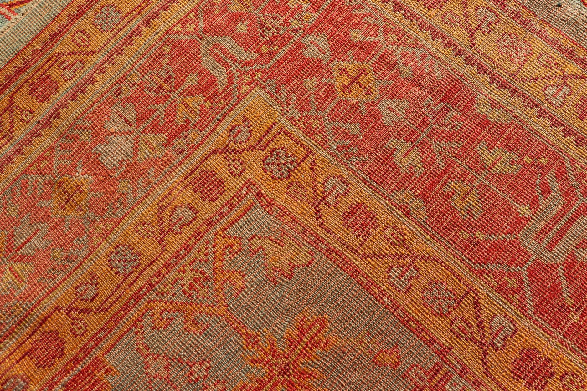 Early 20th century antique Turkish Oushak rug with flowers and geometric motifs in blue background and red border. Keivan Woven Arts / rug L11-0404, country of origin / type: Turkey / Oushak, circa 1910

Produced in early 20th century Turkey, this