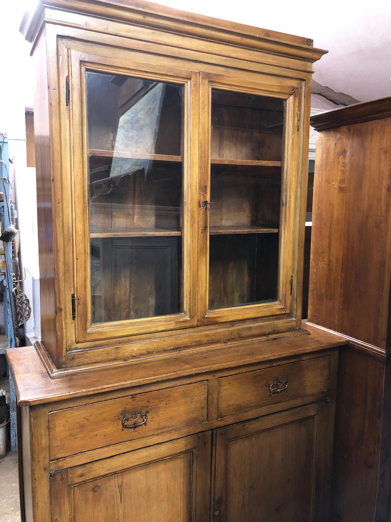 Antique showcase, original Tuscan, in fir.
Very nice for kitchen or living room or study.
It has a glass top, drawer and bottom with two doors.
For easy transport, the upper part separates from the lower part.