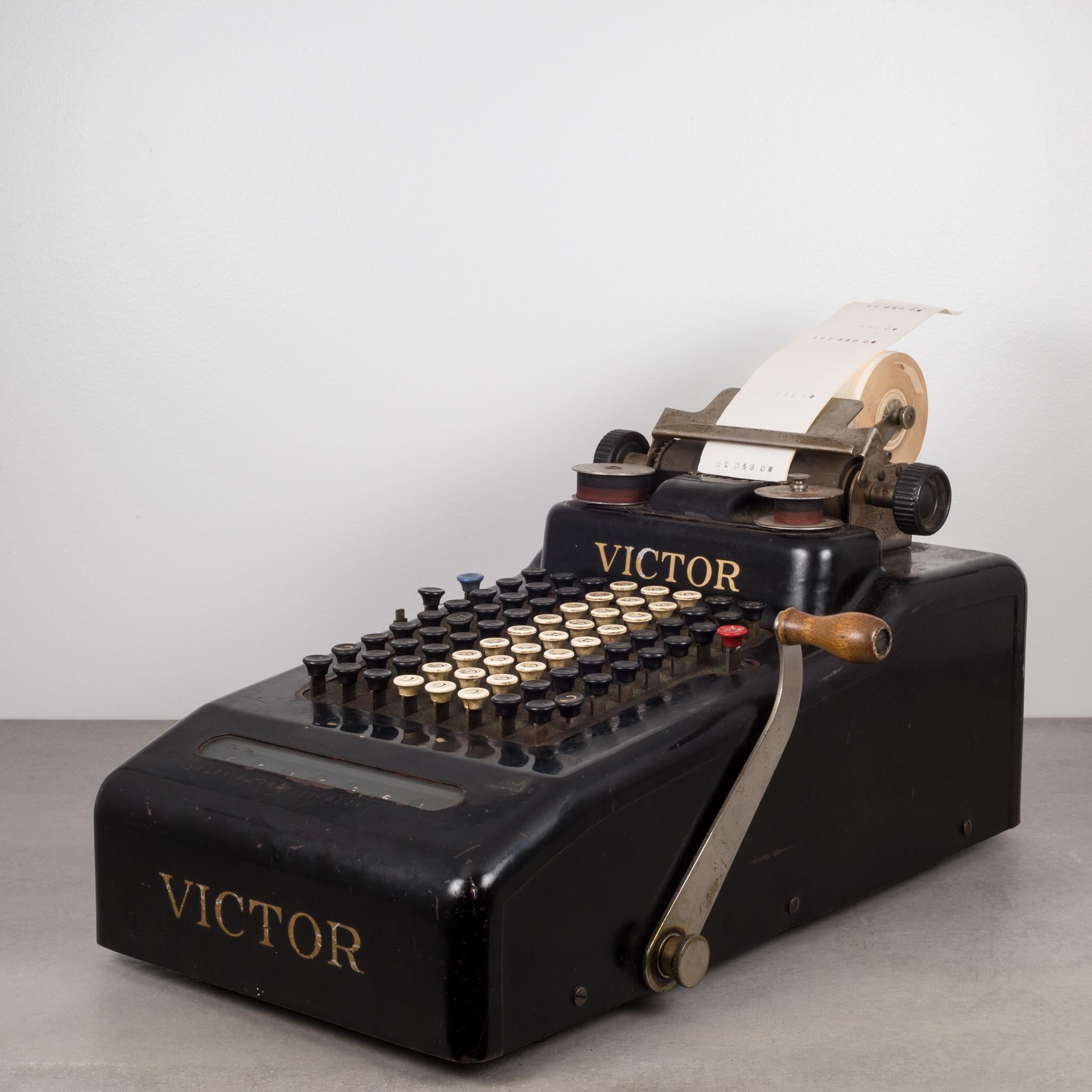 Antique steel and glass adding machine by Victor. The body is steel with a glass window that shows the calculated numbers. The lever has a wooden handle. Pull back lever for a very satisfying sound of numbers adding. The numbers change in the