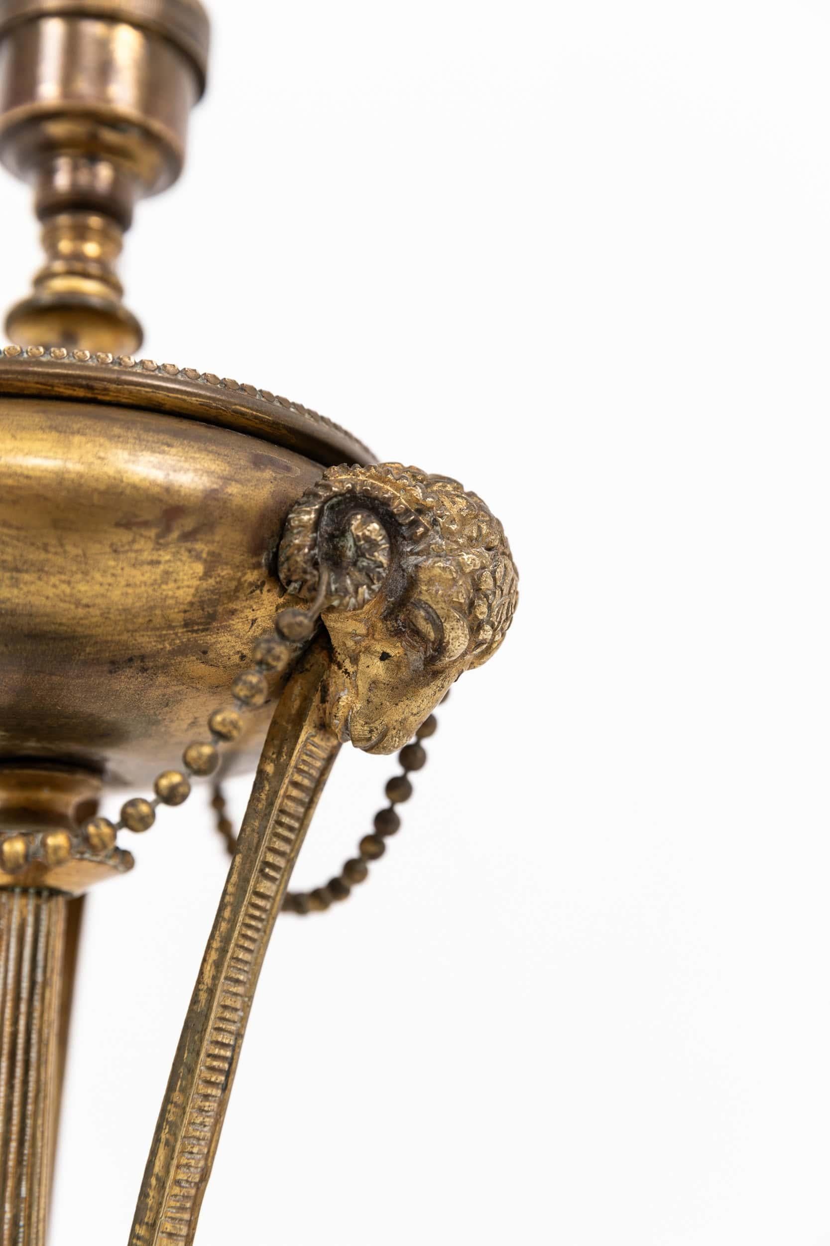 An early 20th century decorative brass table lamp. English, c.1910

Quite possibly made by GEC in the early 20th century. Highly decorative, with rams head motifs and original gilt brass finish. Of high quality, heavy brass construction and original