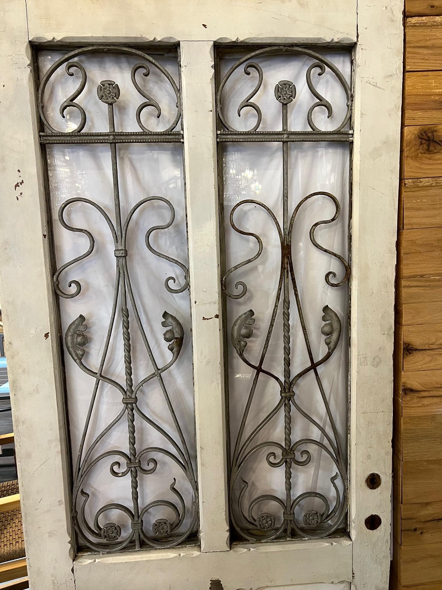 Early 20th Century antique wood entrance door with decorative iron panels and two opening glass door panels. This is a great door salvaged from an estate in western PA. but originally could be from France or Belgium. This door was used as a entrance