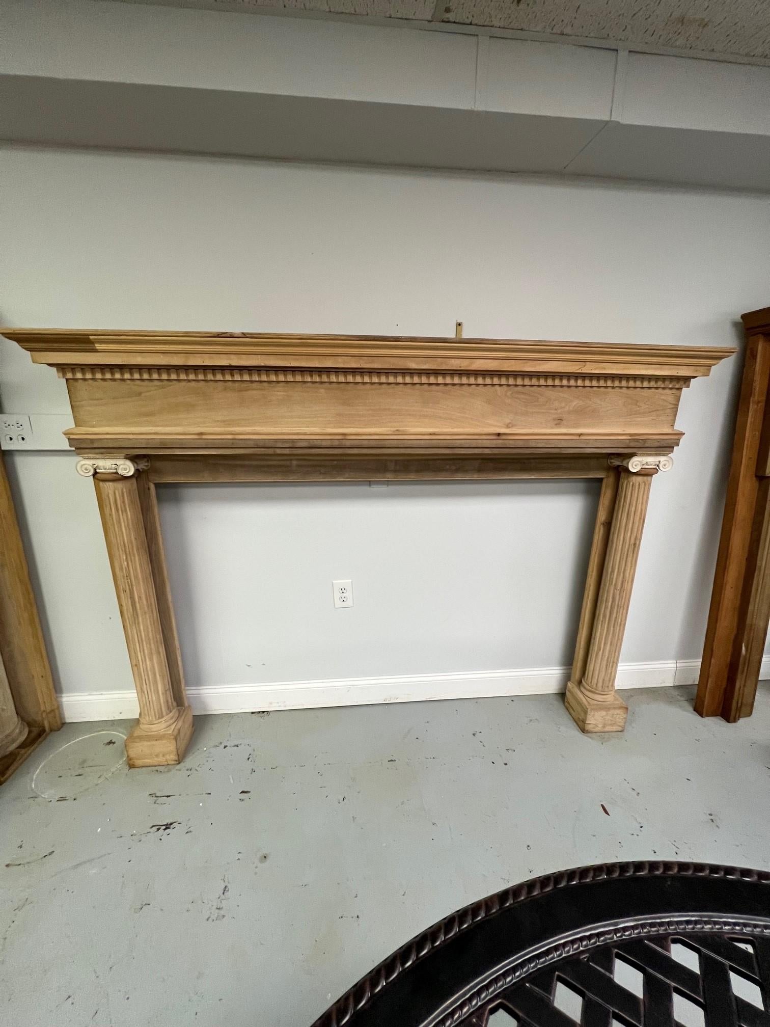 Early 20th century antique wood fireplace mantel with two plain columns with decorative capitals made of gesso, a very nice looking fireplace mantel. Its in good condition and would look great painted only needing a light sanding. This mantel was