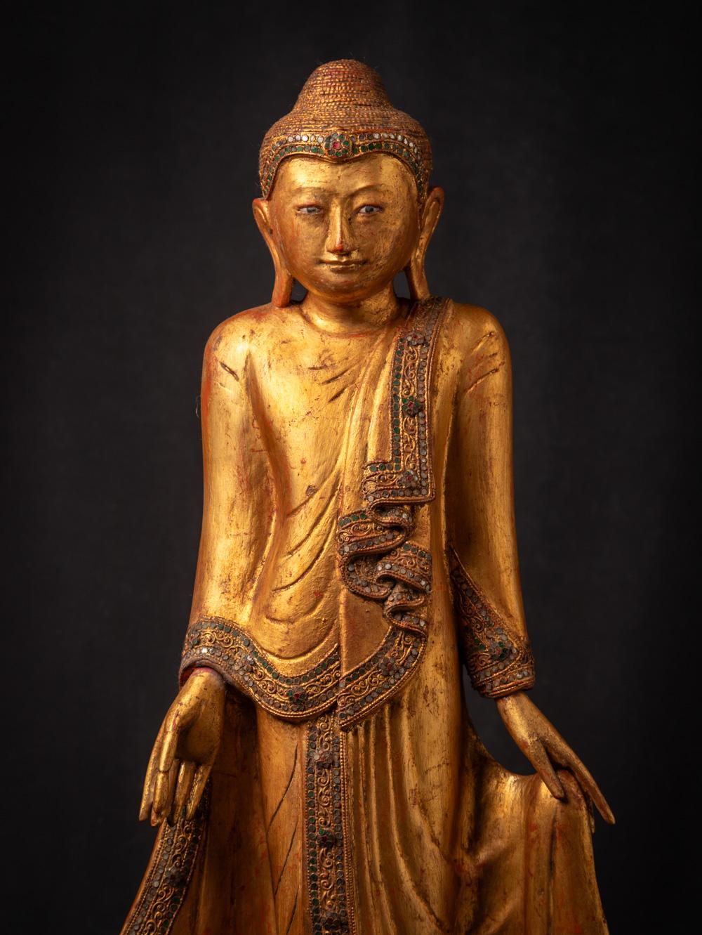 This Antique wooden Mandalay Buddha statue from Burma during the Early 20th century, is a fine example of Mandalay style craftsmanship. It stands at a height of 88,5 cm and boasts dimensions of 36,5 cm in width and 24,2 cm in depth, making it a