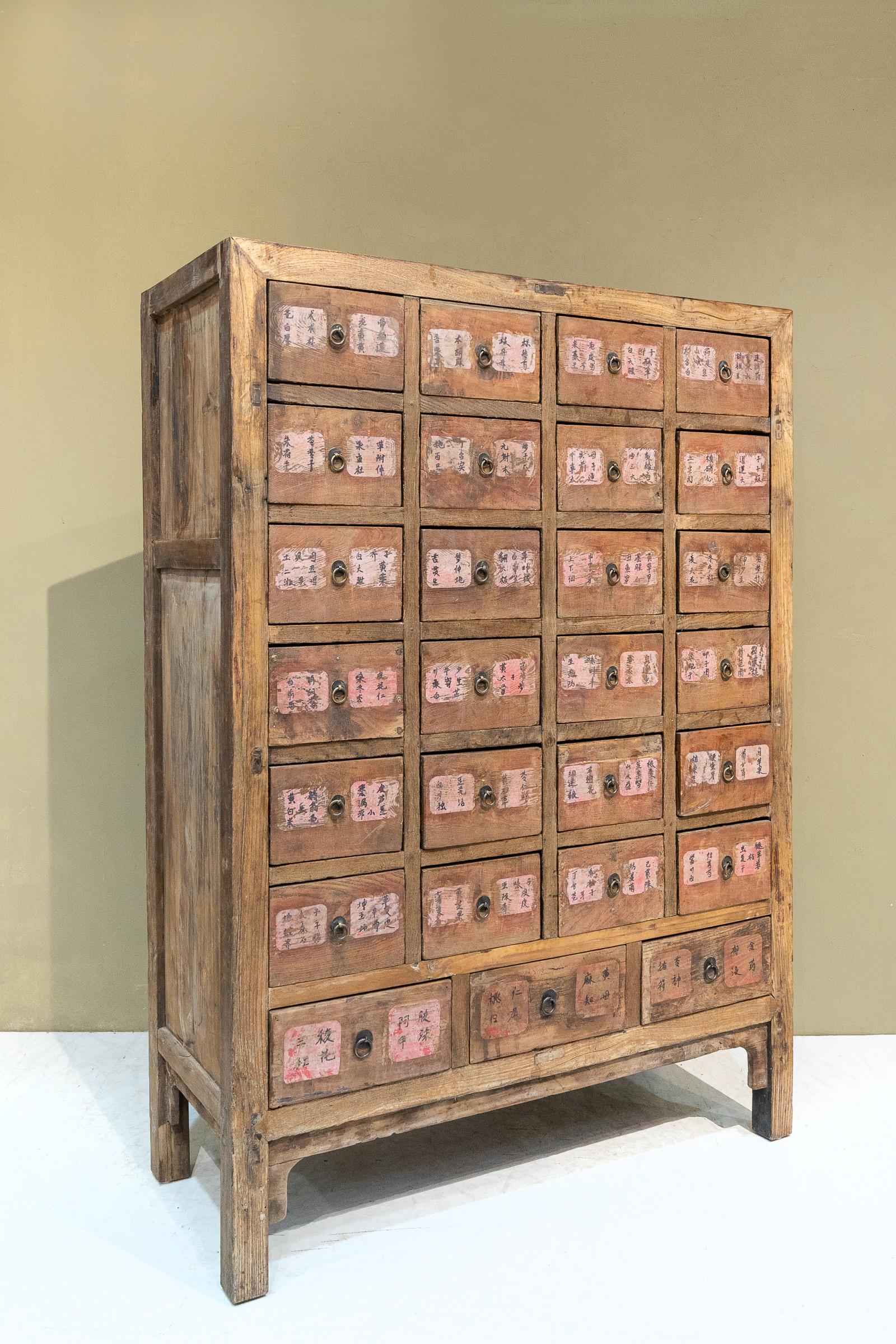 Early 20th century Chinese apothecary cabinet from Shanxi province, China. These were used to store and organize Chinese herbs and the names of the herbs kept in each drawer are written on the front. The names in this case were written on thin red