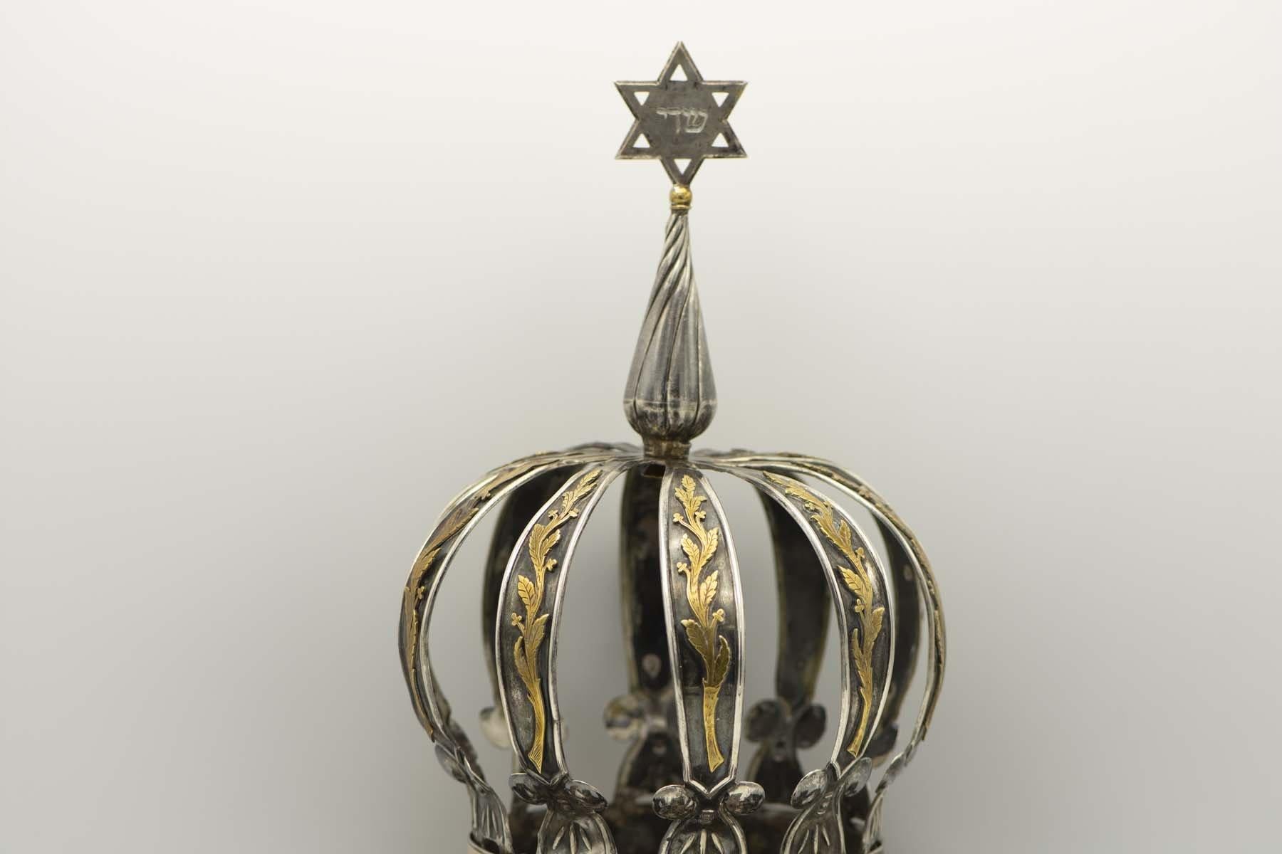 Silver and gold Torah crown, Buenos Aires, Argentina, 1925.
On silver base decorated with a small gold Stars of David. The lower ribs decorated with applied lattice work holding up a second crown topped with a Star of David. The upper gold band